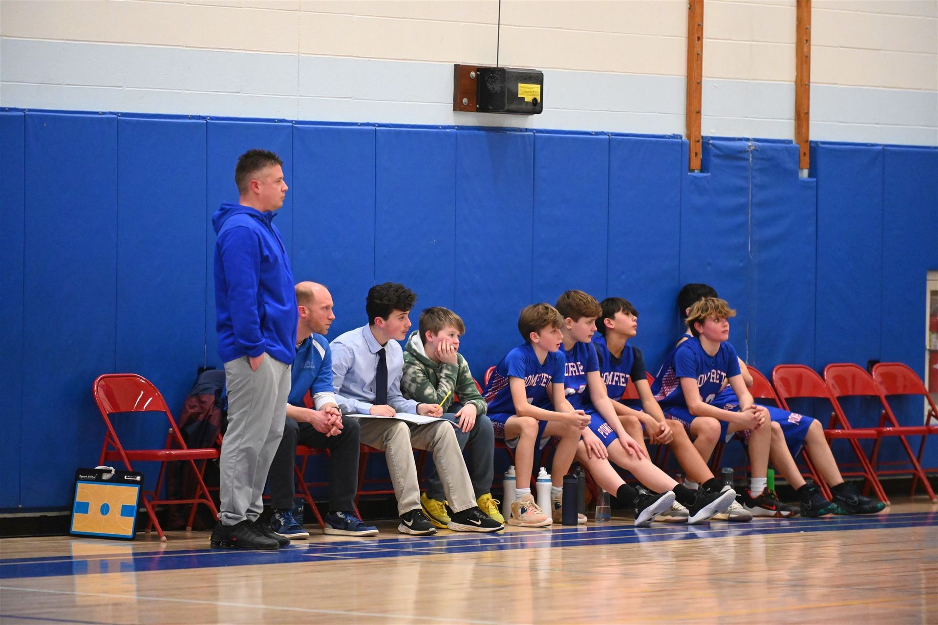 some of the 2023-24 boys basketball team and their coaches sitting on the
sidelines