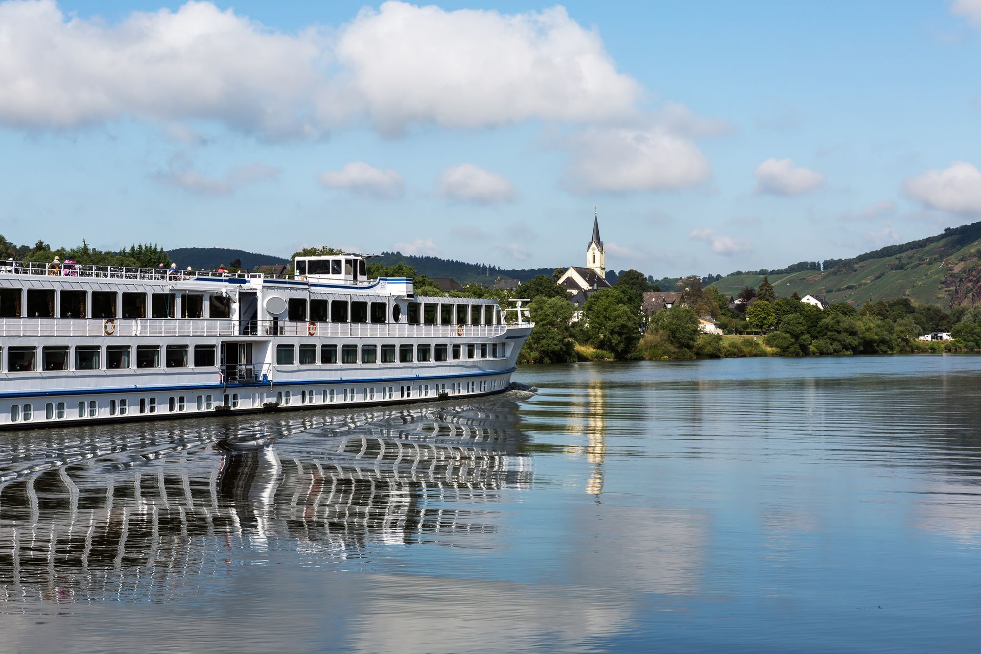 A large white and blue boat is floating on a body of water.