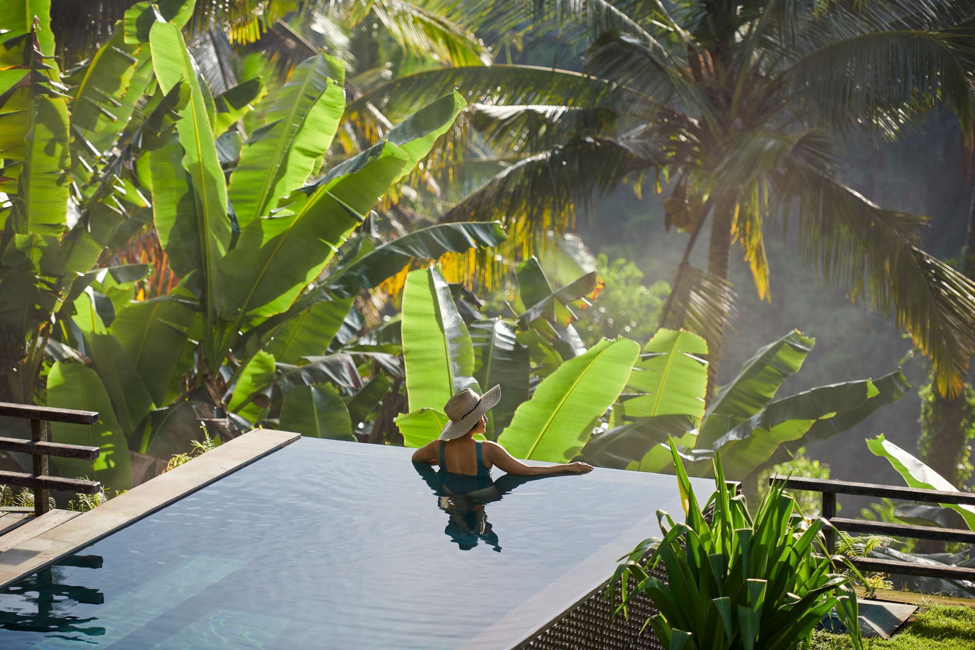 Woman in jungle infinity pool.