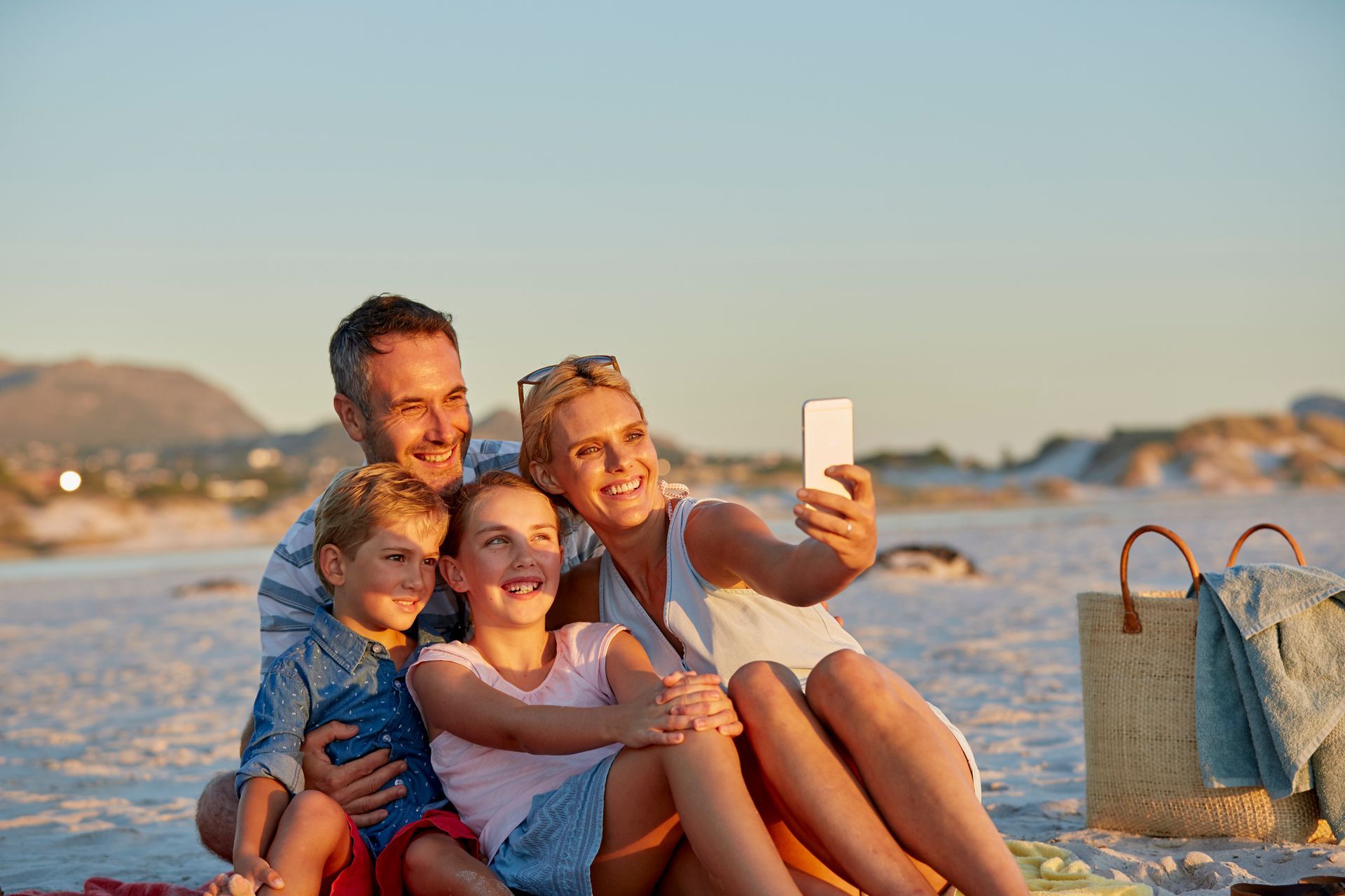 A family is taking a selfie on the beach.