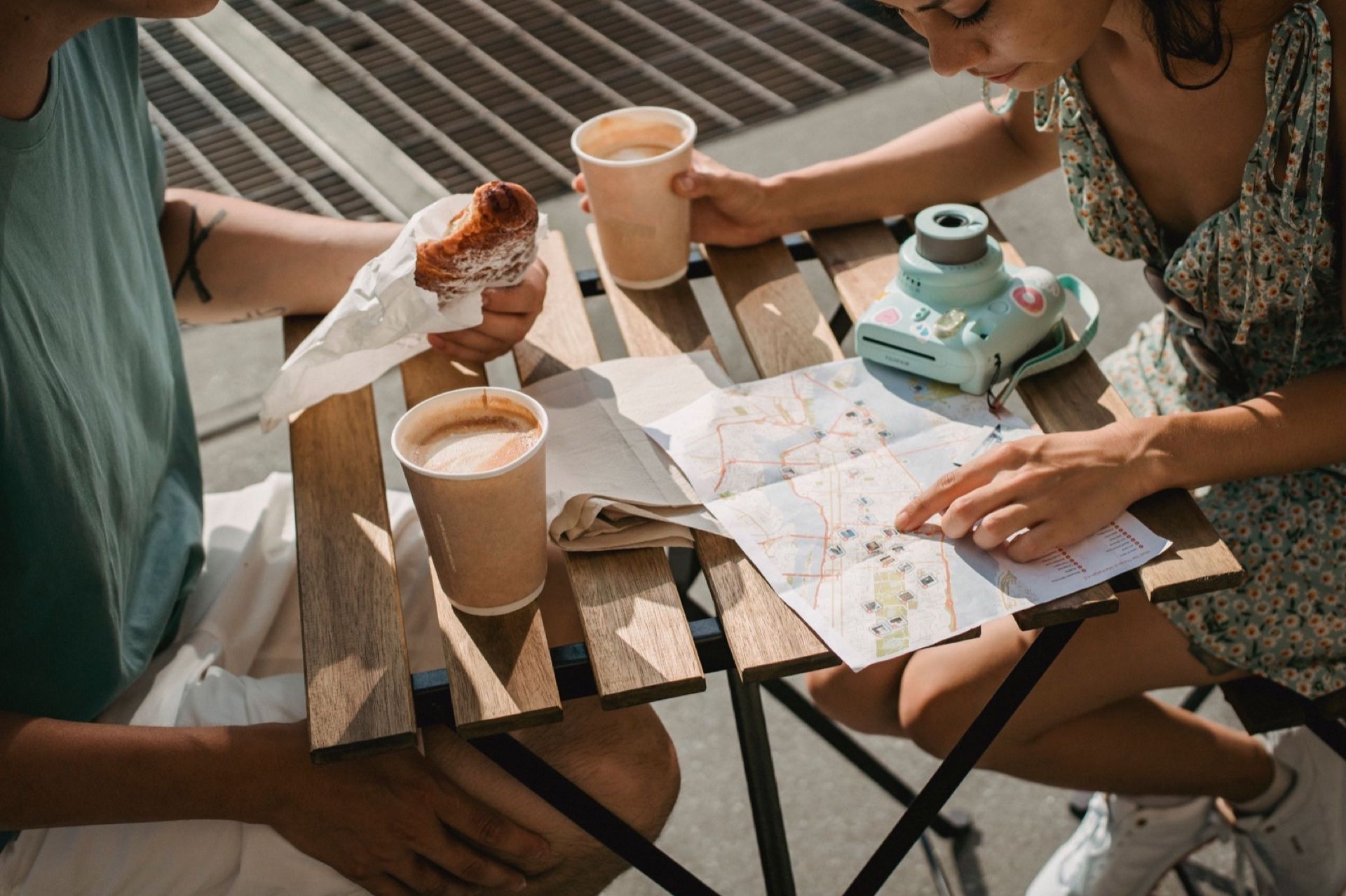 Coffee, a map, and travel plans spread across a cafe table