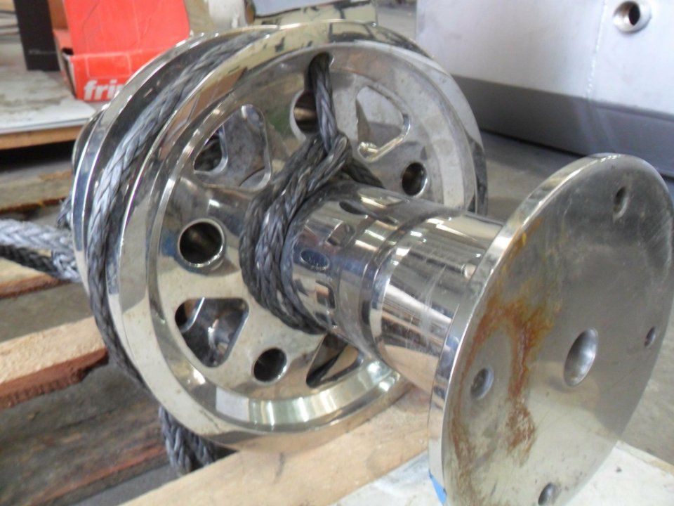 Bobina o avvolgitore industriale in metallo lucido con flange cromate lucide su un banco da lavoro