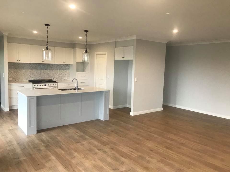 An Empty Kitchen with A Large Island in The Middle of The Room — Andrew Klein Painting in Toowoomba, QLD