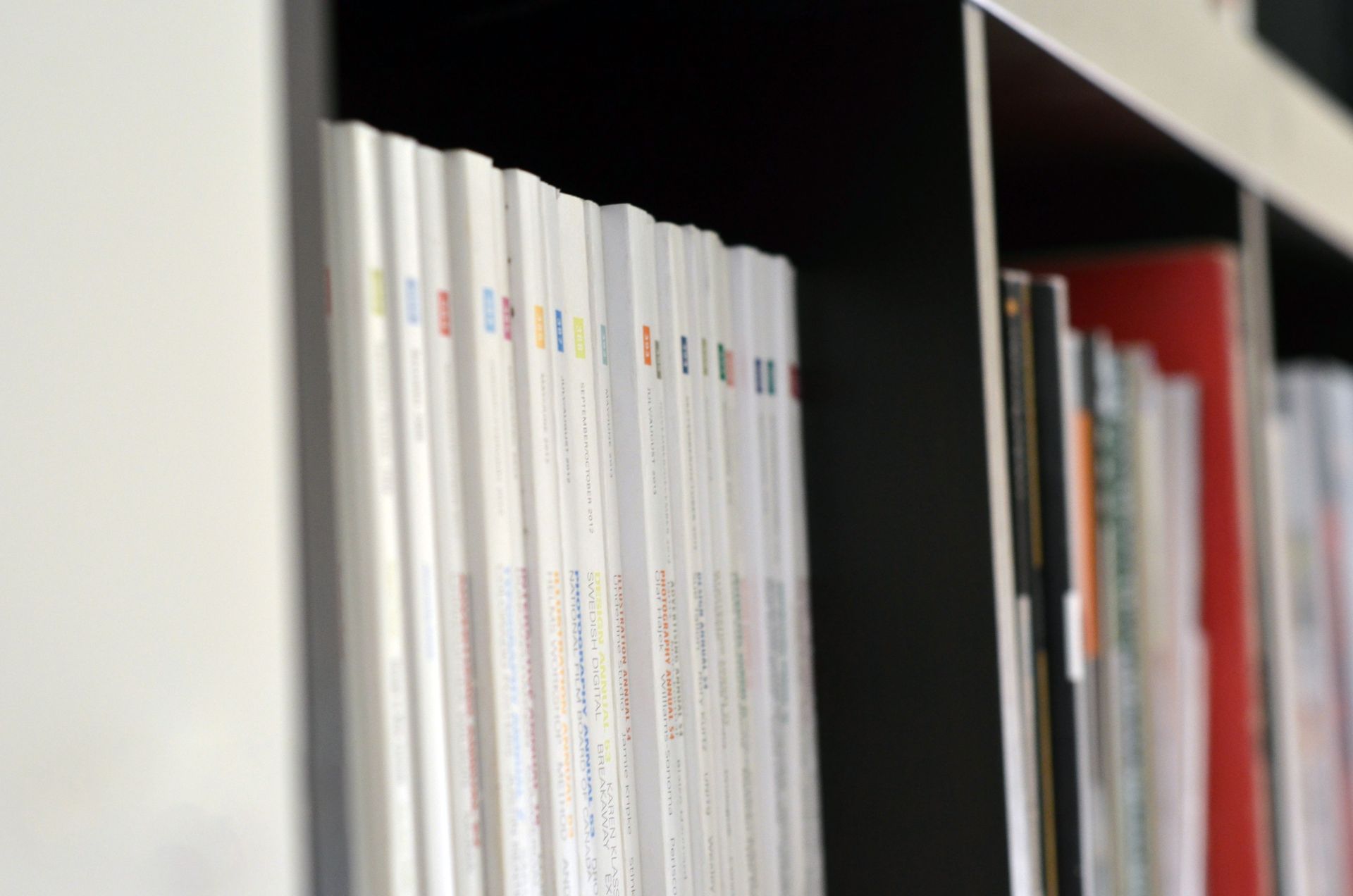 A shelf filled with lots of books and magazines.