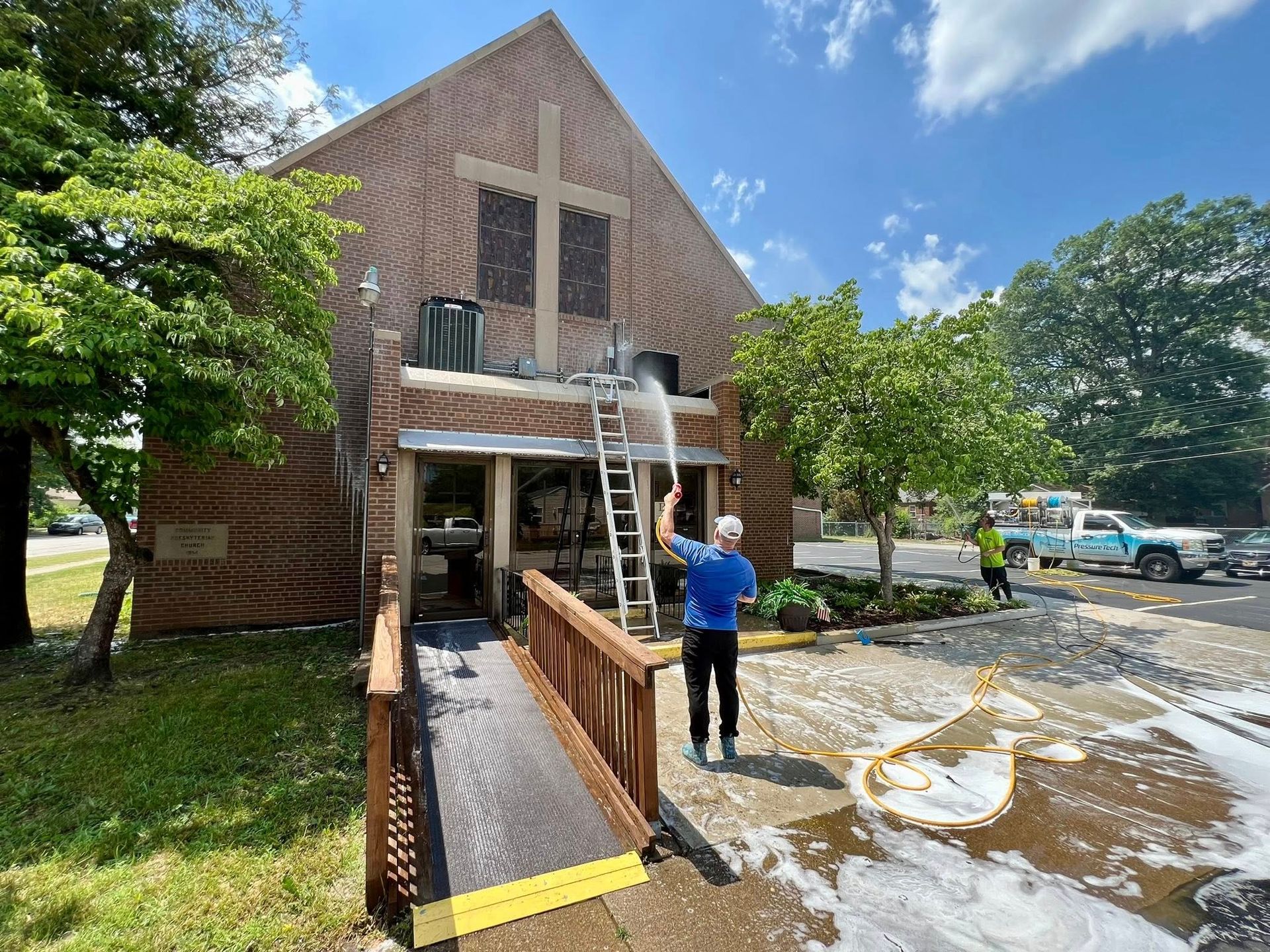 Brick building with ramp and floodwater outside; person stands near the entrance in a blue shirt