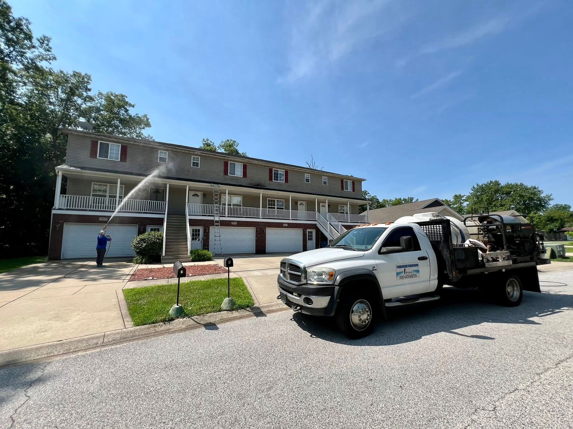 Tow truck parked outside a rowhouse apartment building on a sunny day