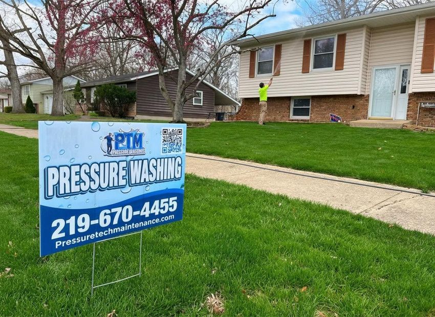 Yard sign for pressure washing service in front of a suburban house and lawn