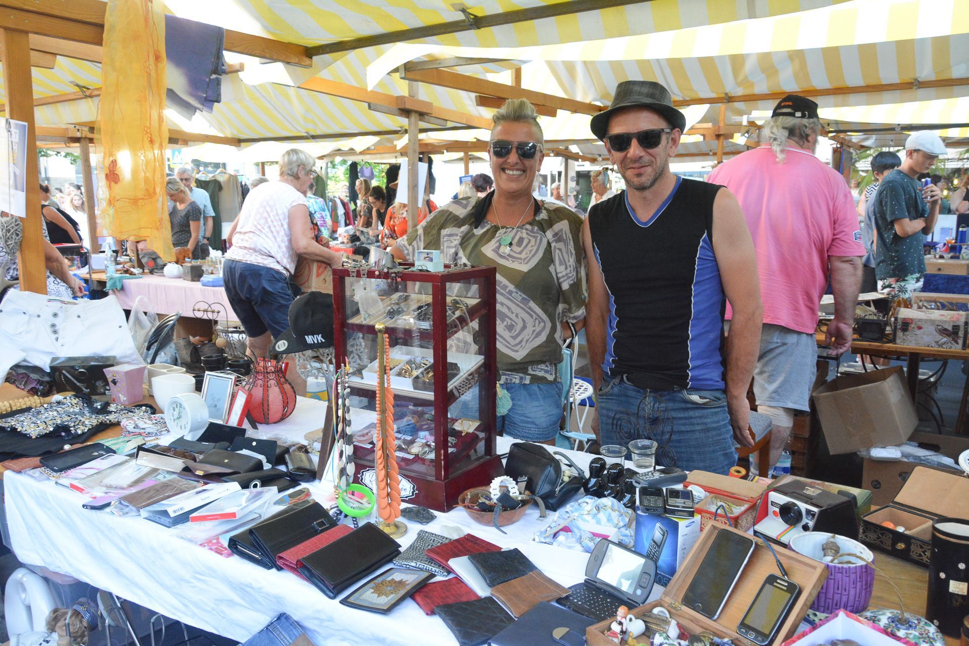 Zwei Männer stehen vor einem Tisch auf einem Flohmarkt.