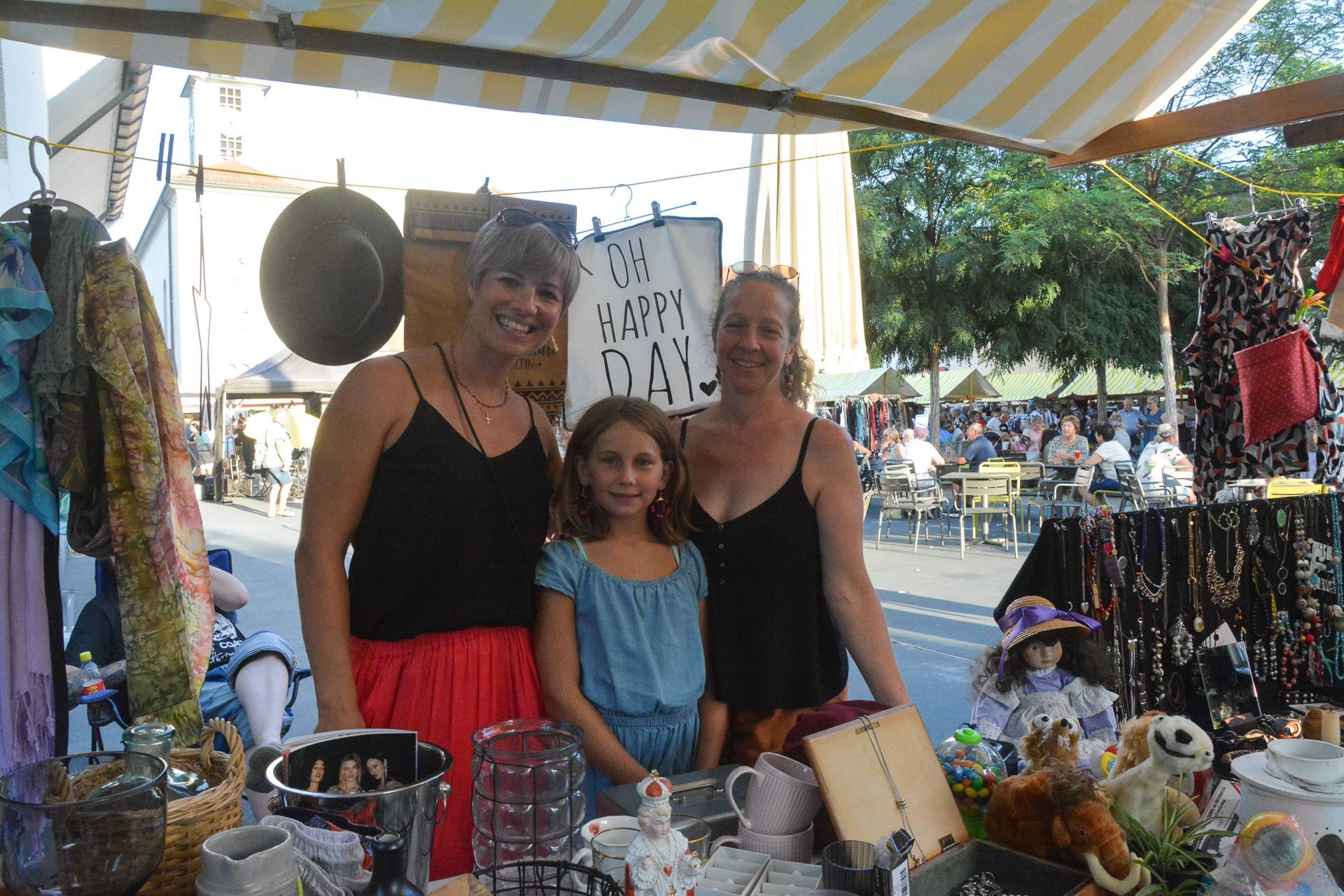 Drei Frauen und ein kleines Mädchen posieren auf einem Markt für ein Foto.