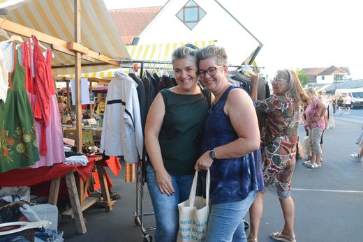 Zwei Frauen posieren für ein Foto auf einem Markt