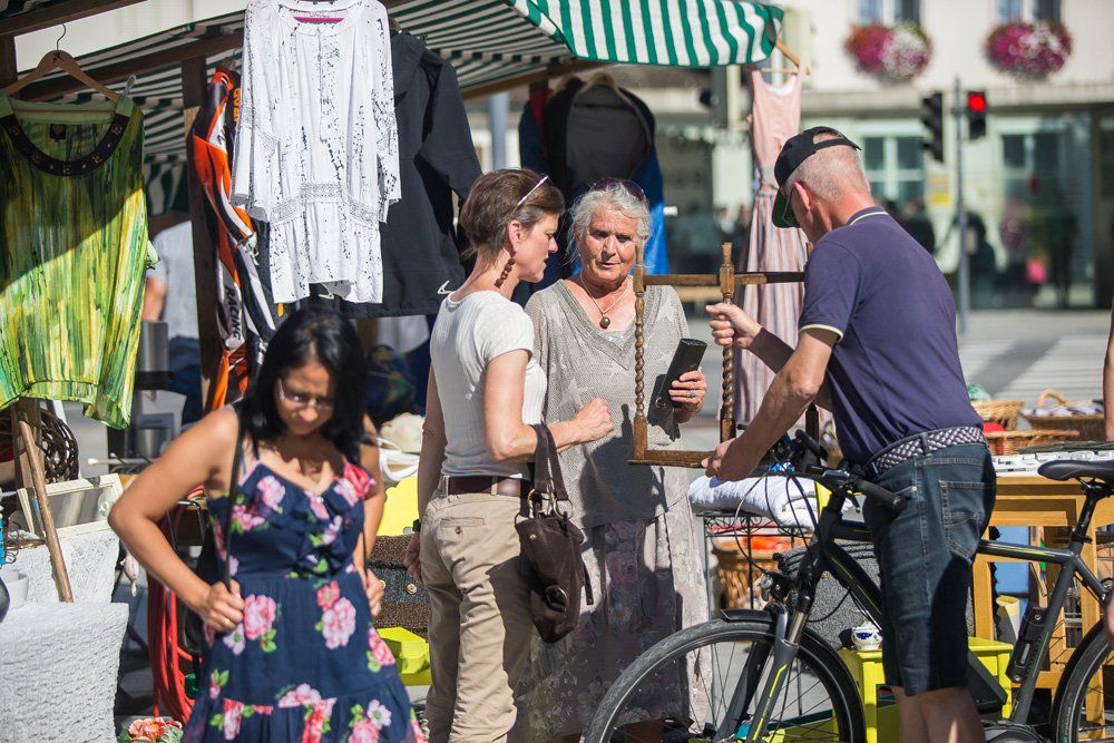 Auf einem Markt steht eine Gruppe von Menschen um ein Fahrrad herum.