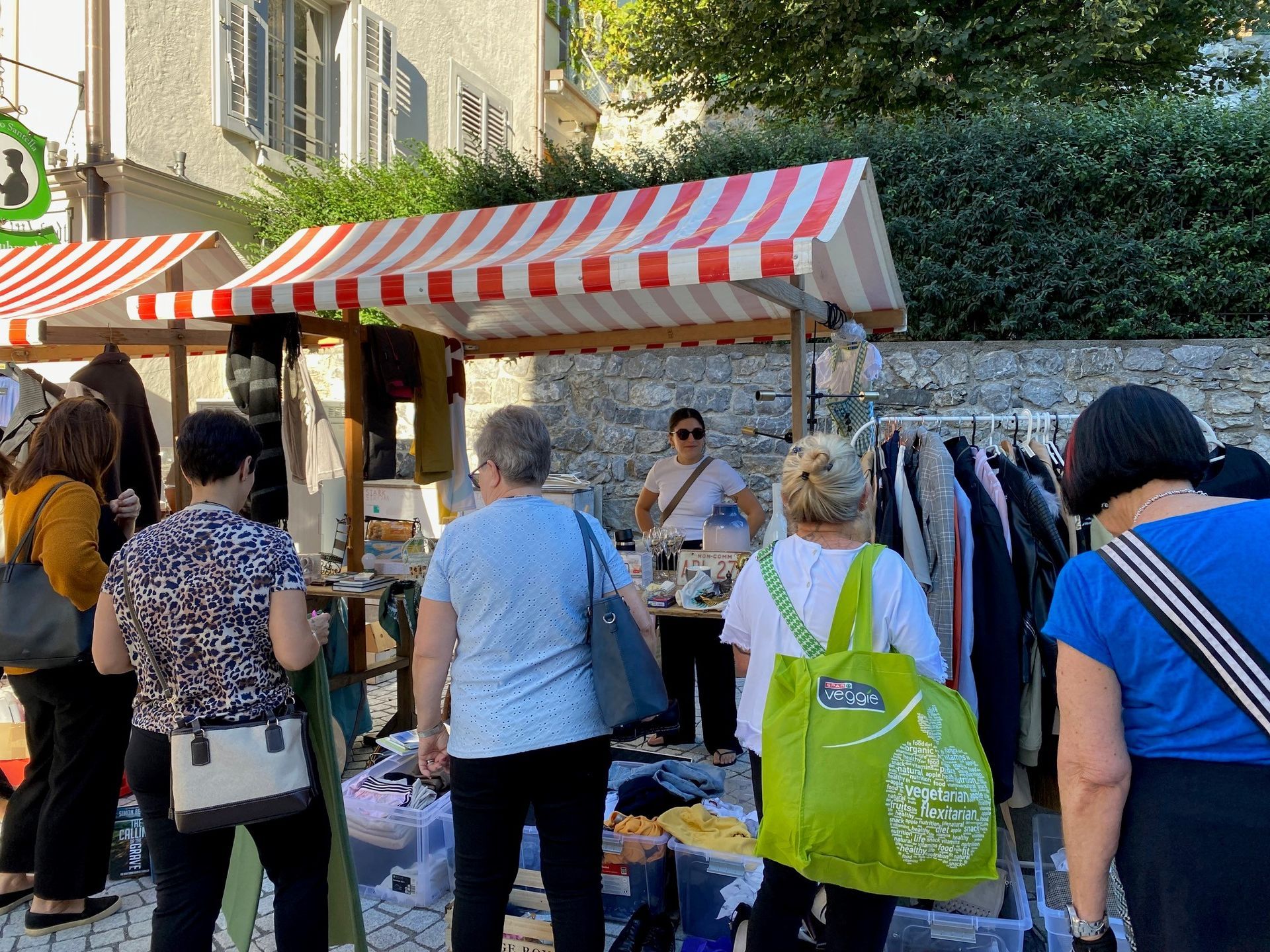 Eine Gruppe von Leuten geht auf einem Flohmarkt einkaufen.