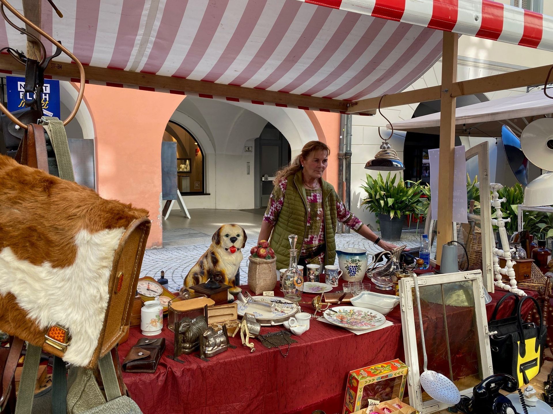 Eine Frau steht hinter einem Tisch auf einem Flohmarkt.