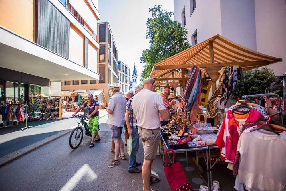 Auf einem Markt steht eine Gruppe von Menschen um einen Tisch herum.