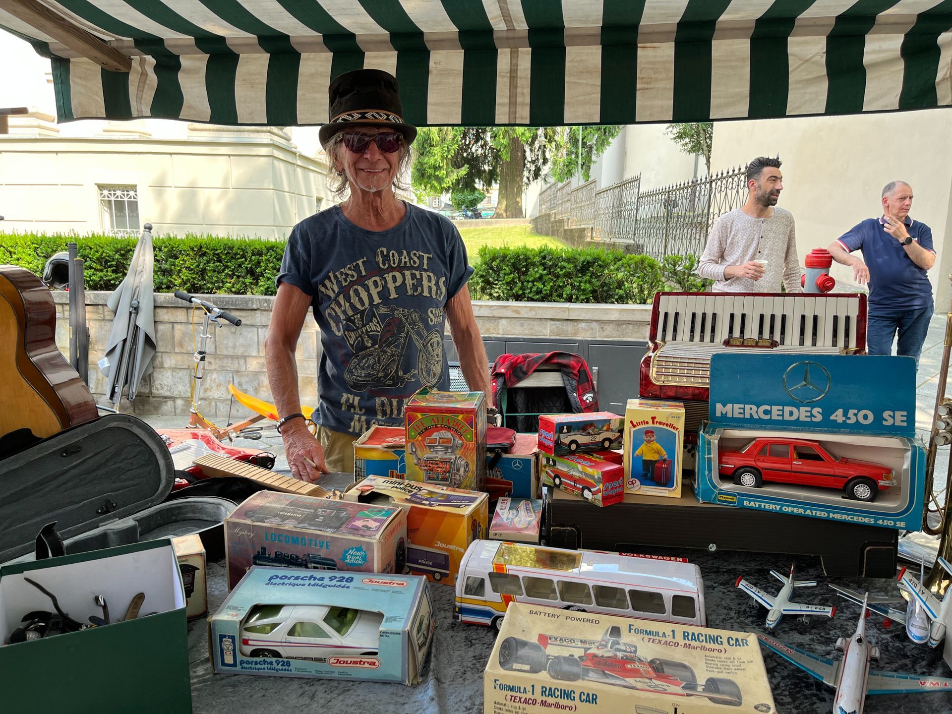 Ein Mann steht vor einem Tisch voller Spielsachen.