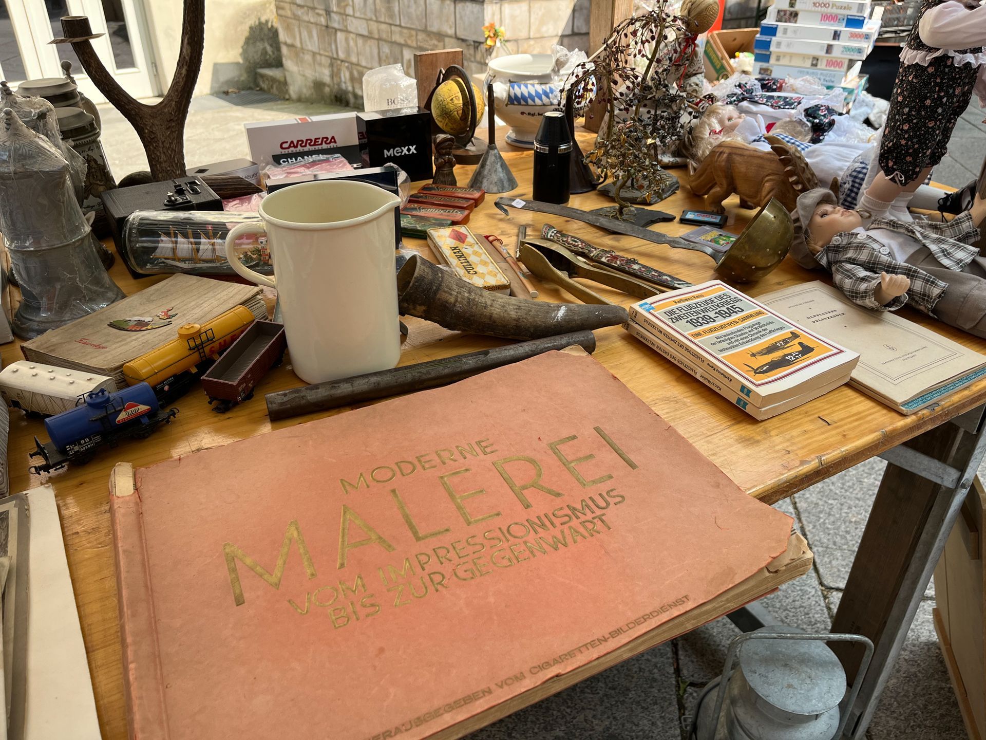 Ein Holztisch mit einem Buch mit dem Titel „Malerei“ darauf.