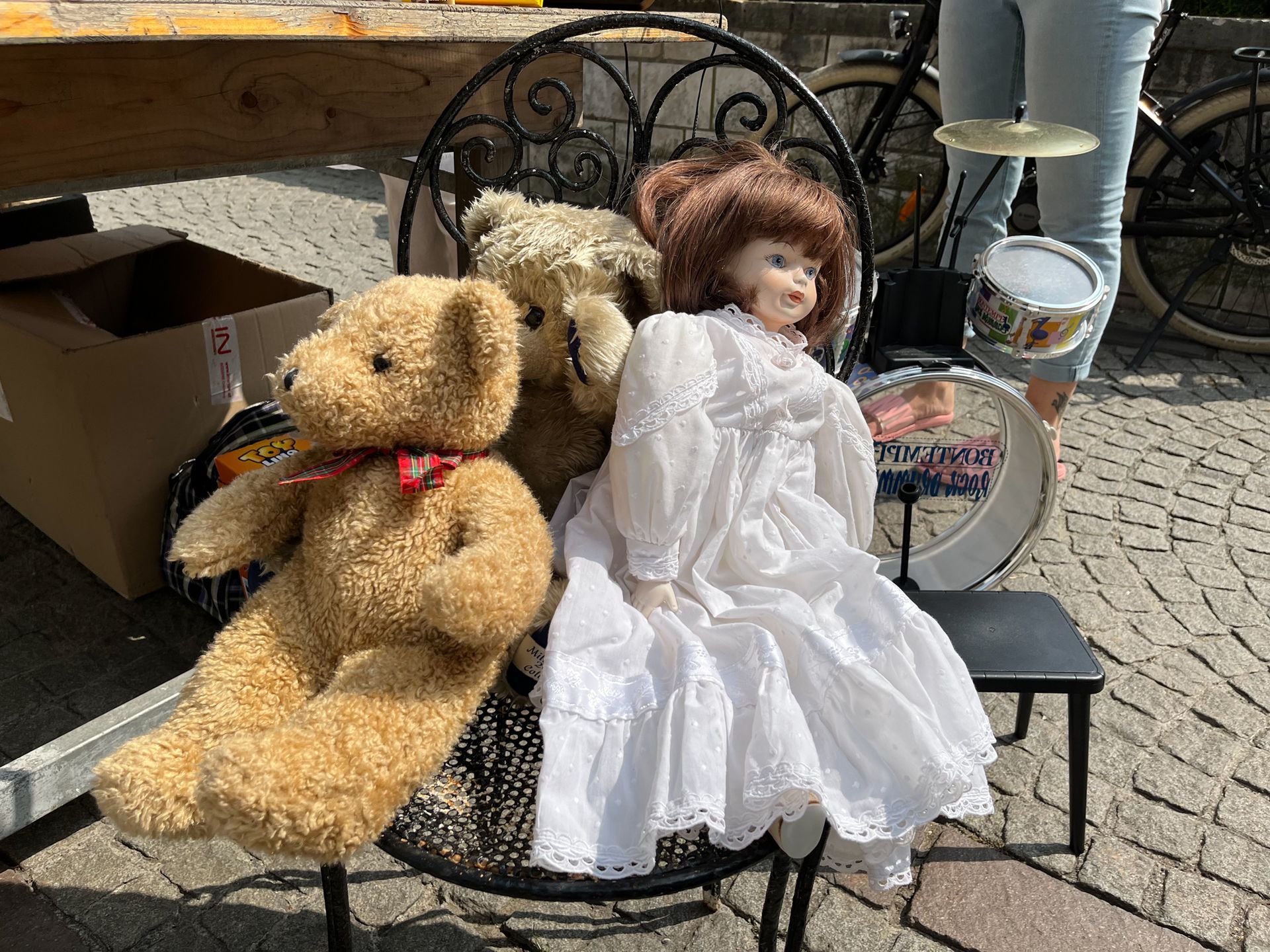 Ein Teddybär und eine Puppe sitzen auf einem Stuhl.