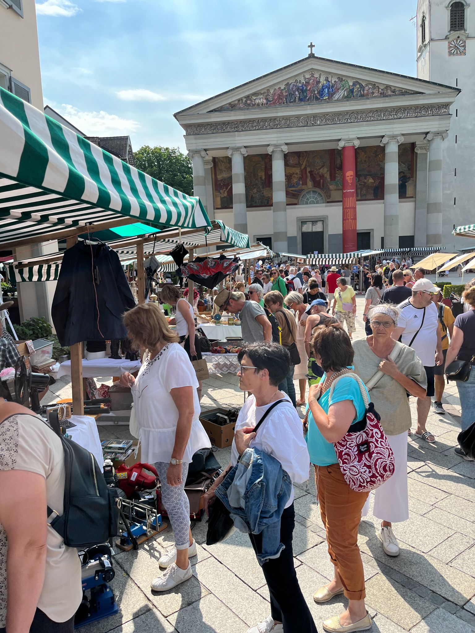 Eine Menschenmenge steht vor einem Gebäude auf einem Flohmarkt.