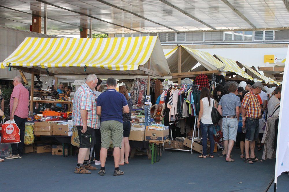 Eine Gruppe von Menschen steht auf einem Markt herum.