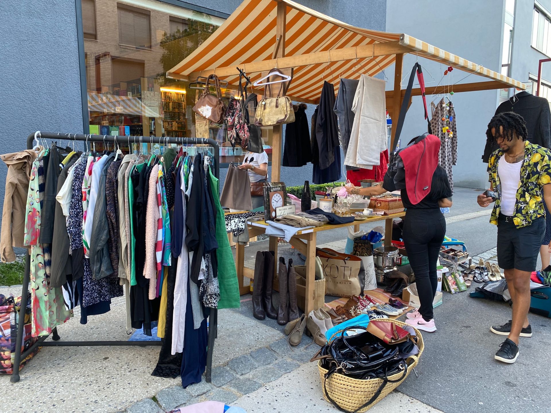 Eine Gruppe von Leuten geht auf einem Flohmarkt einkaufen.