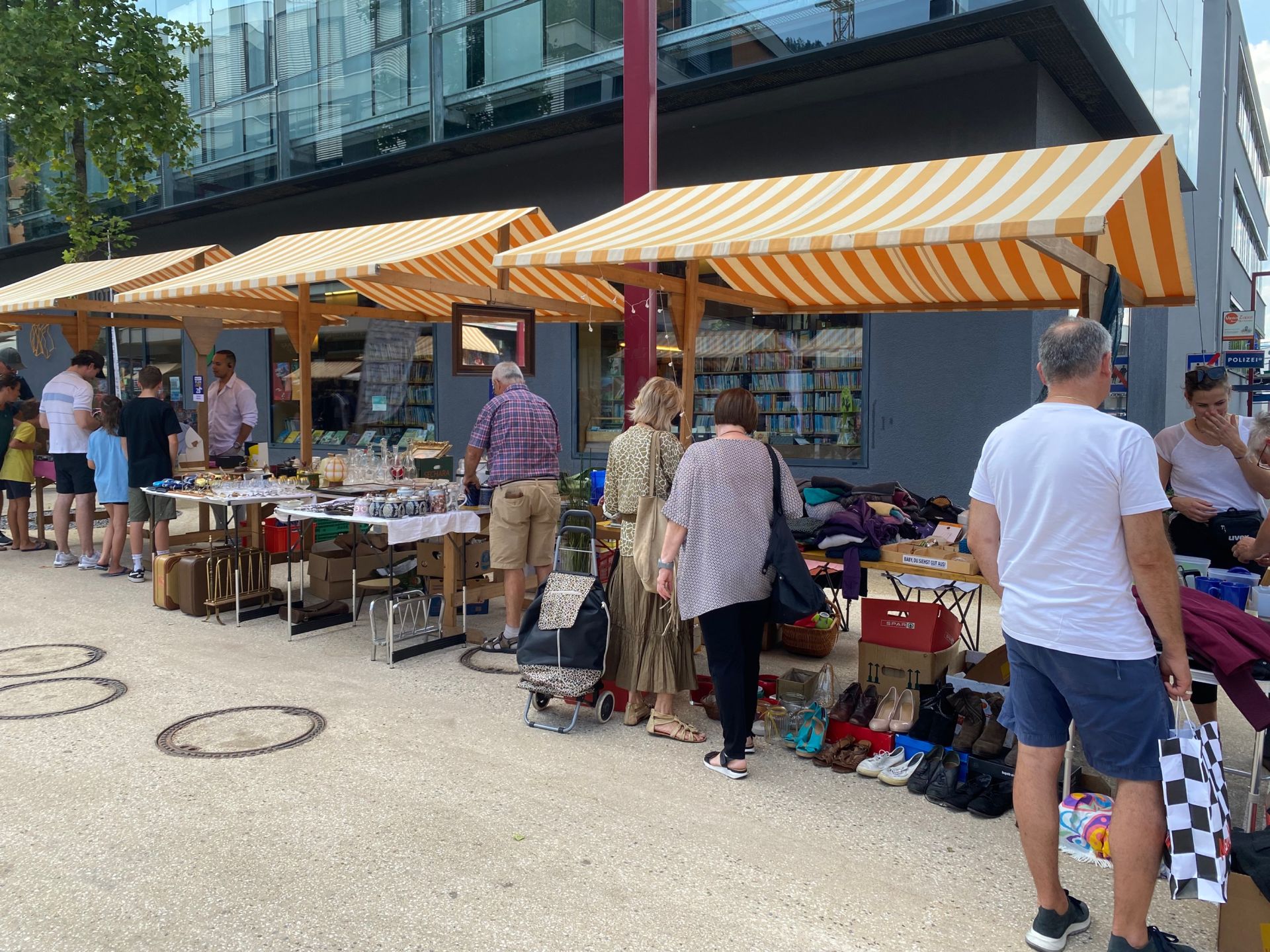 Eine Gruppe von Menschen steht vor einem Markt.