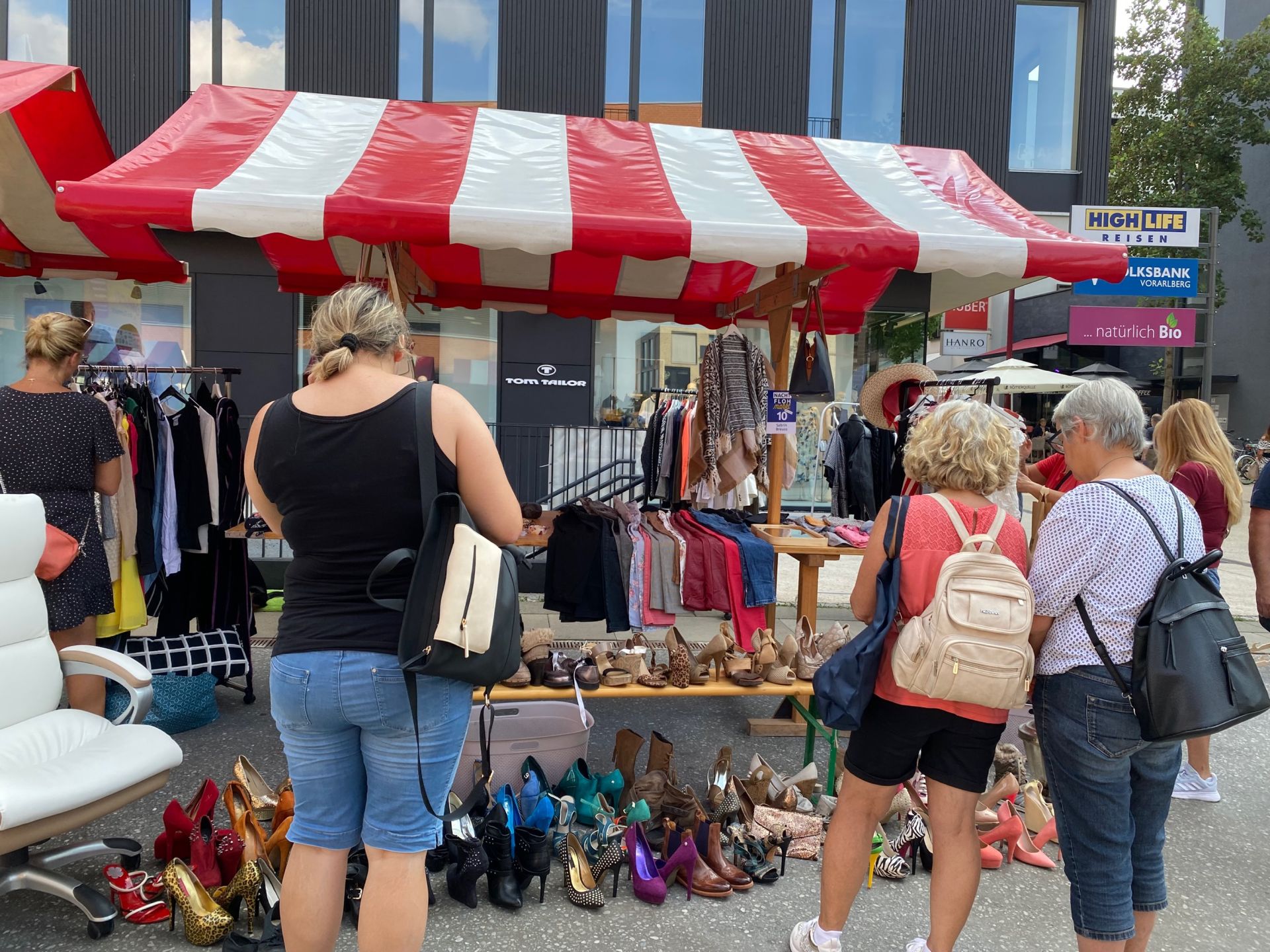 Eine Gruppe Frauen steht vor einem rot-weiß gestreiften Zelt.