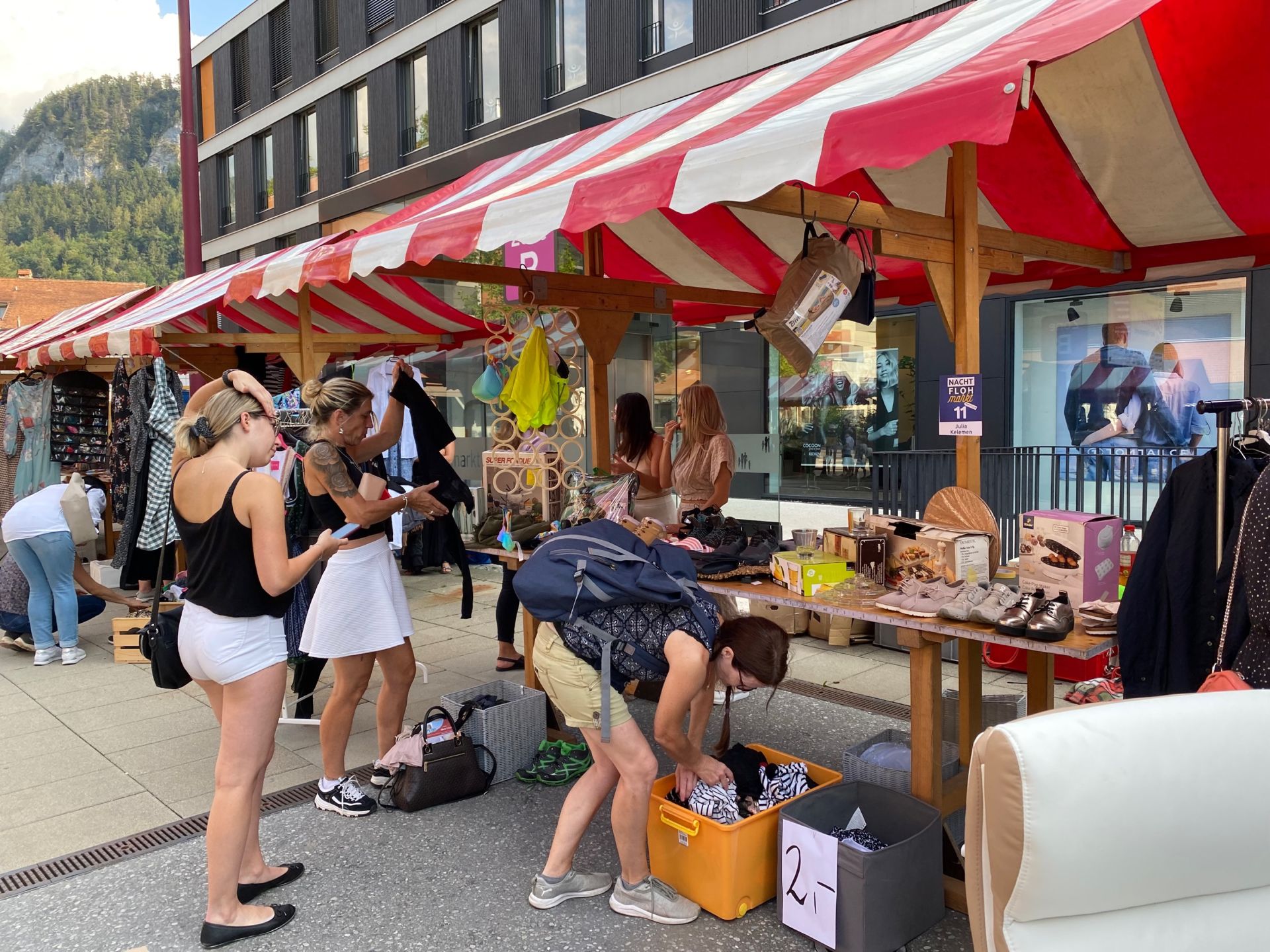 Eine Gruppe von Menschen steht auf einem Markt herum.