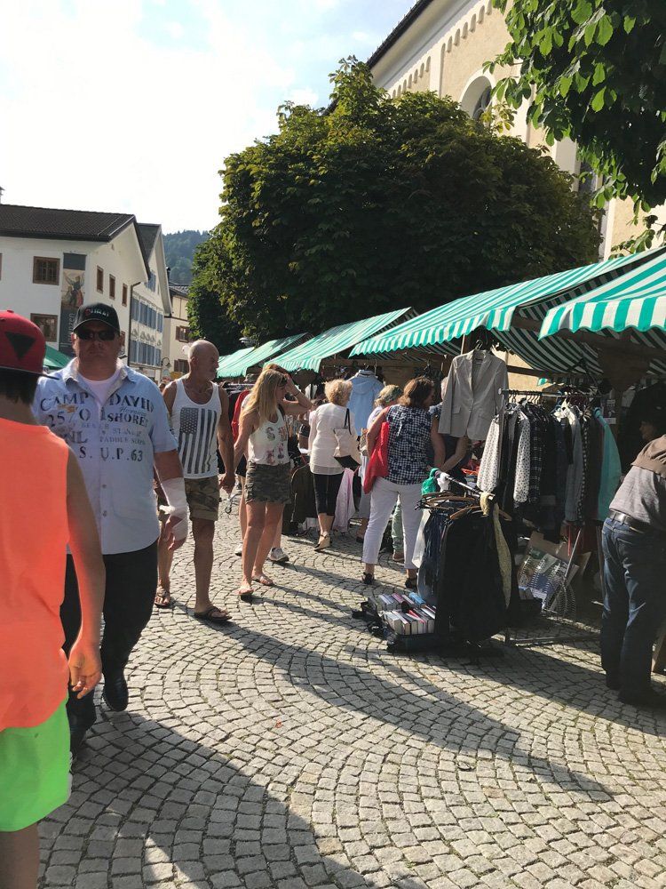 Eine Gruppe von Menschen geht eine gepflasterte Straße entlang.