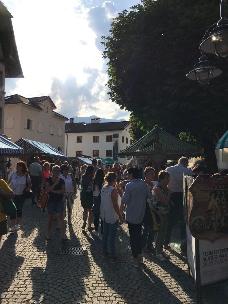 Eine Gruppe von Menschen geht eine Kopfsteinpflasterstraße entlang.