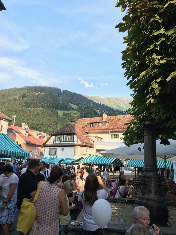 Eine Menschenmenge hat sich in einem Park mit Bergen im Hintergrund versammelt.