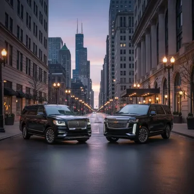 Two black SUVs parked on a city street at dusk, the skyline in the background.