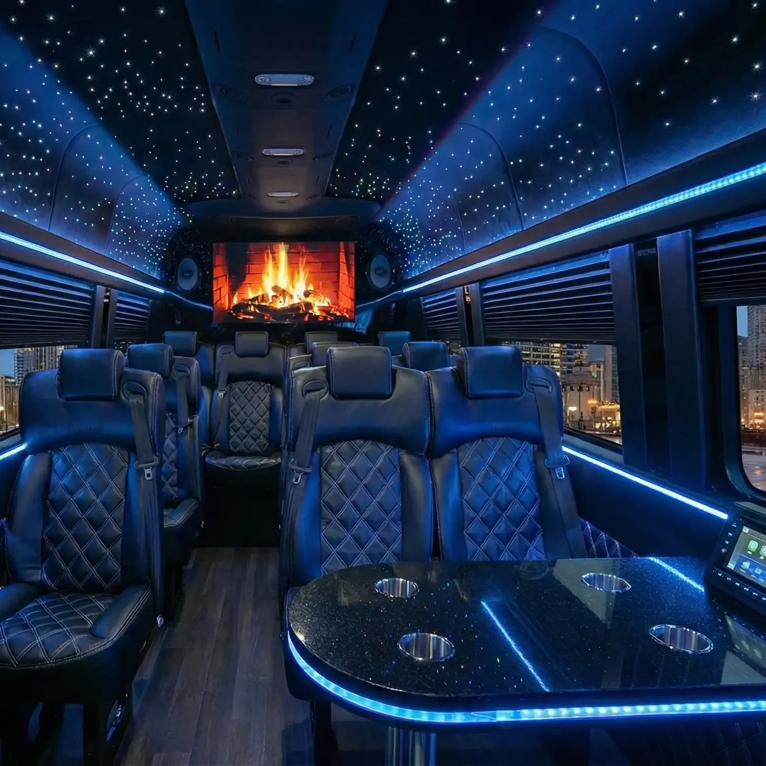 Mercedes Benz Luxury Sprinter Van interior with leather seats, starry ceiling lights, televisions, and table.