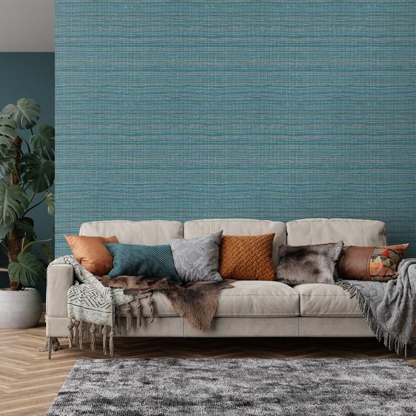 Modern living room with cream sofa, teal wall, and patterned throw pillows and blankets
