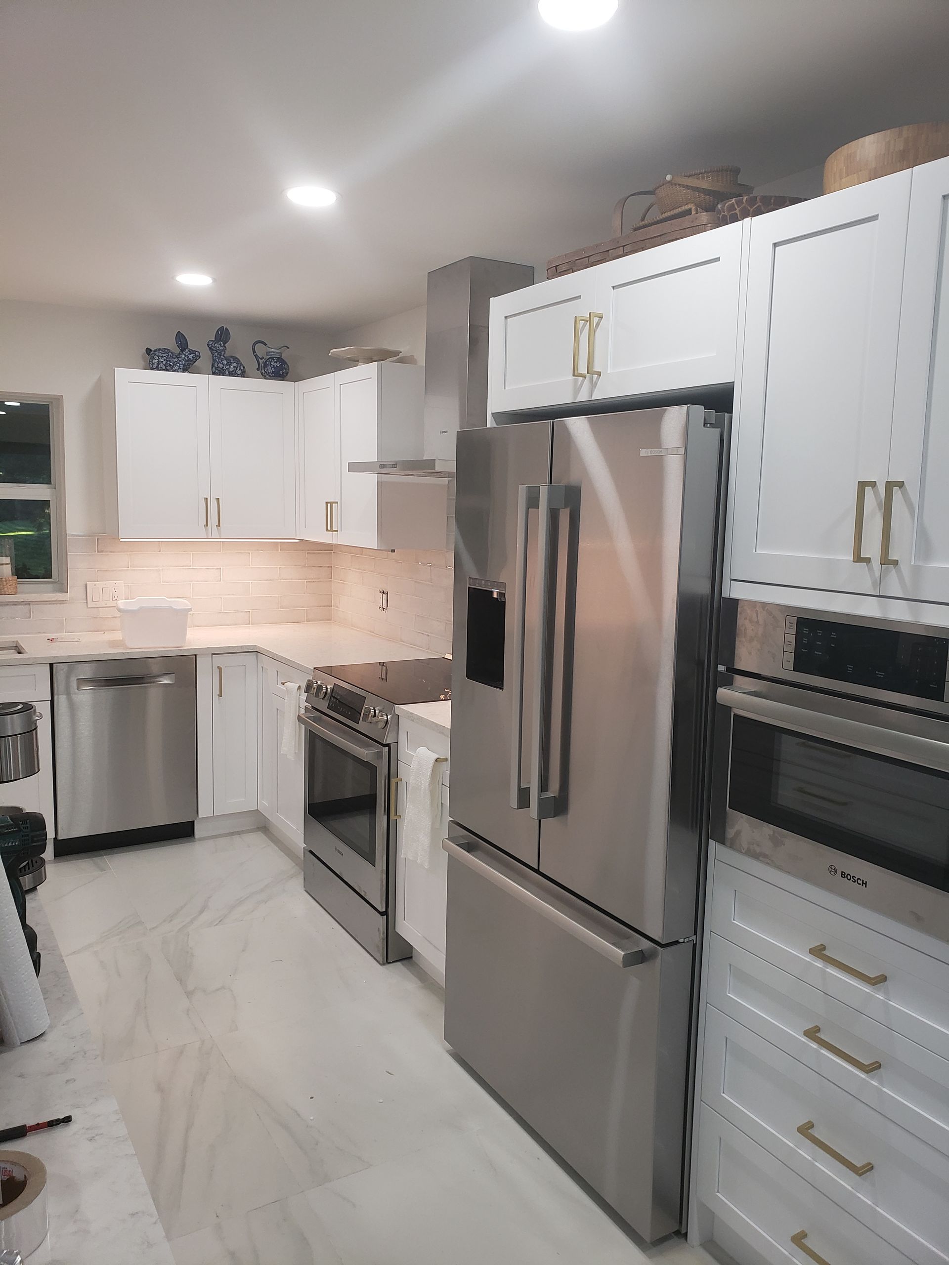 A kitchen with stainless steel appliances and white cabinets.