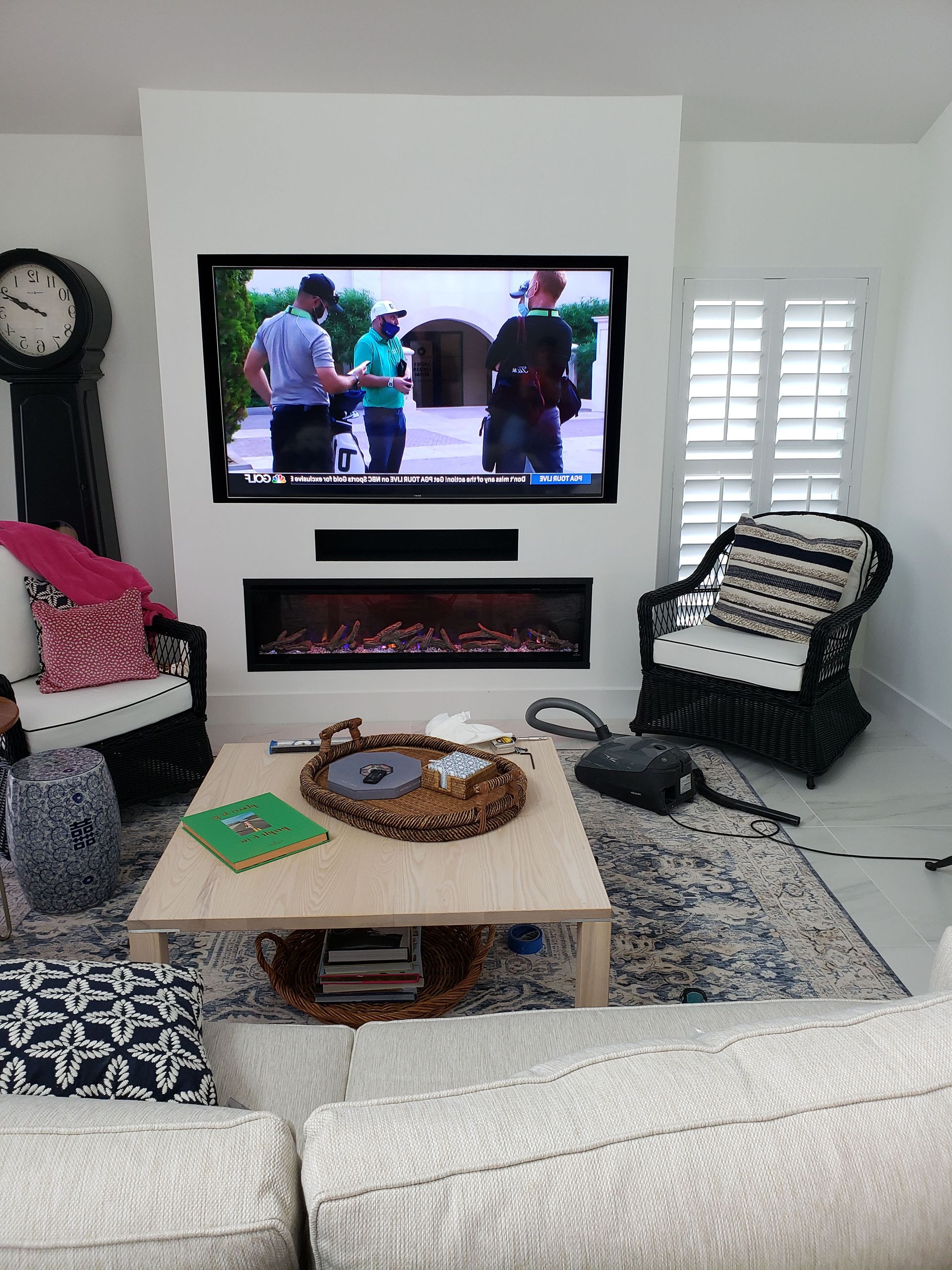 A living room with a fireplace and a flat screen tv on the wall.