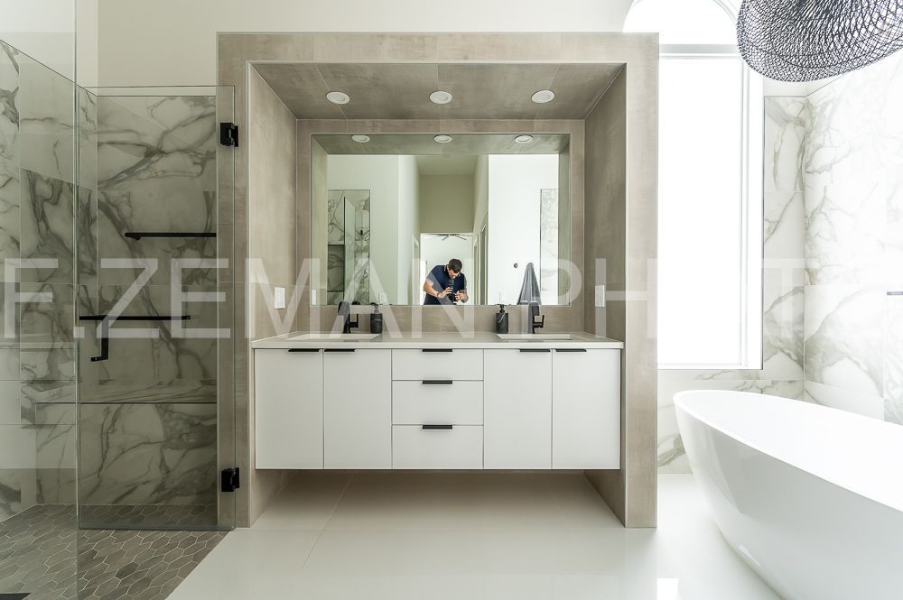 A bathroom with two sinks , a tub and a shower.