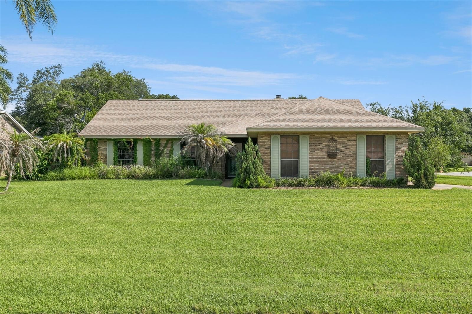 PHOTO OF A HOME WITH BEAUTIFUL GREEN GRASS AND BLUE SKIES
