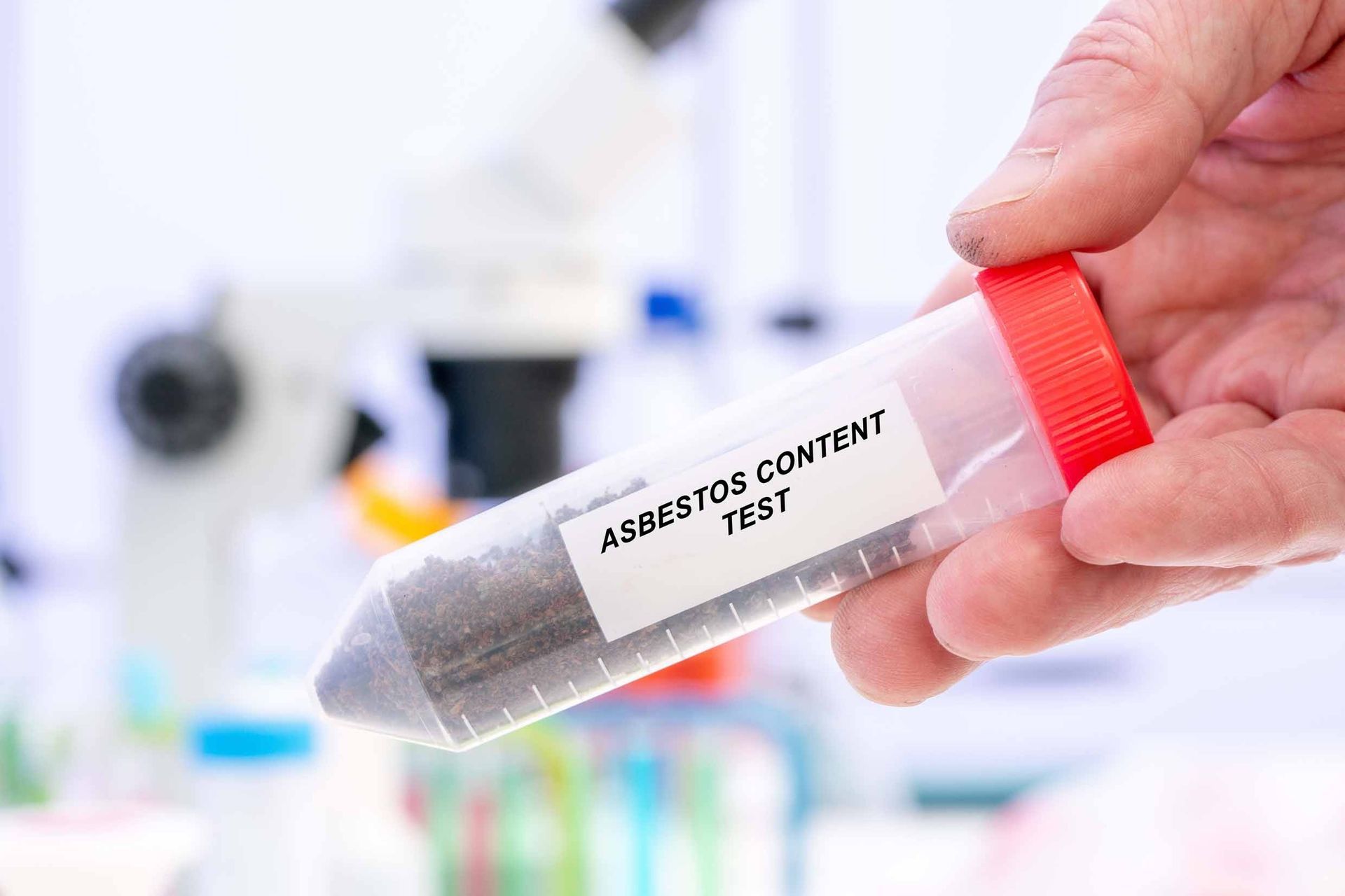 Hand holding a test tube labeled 