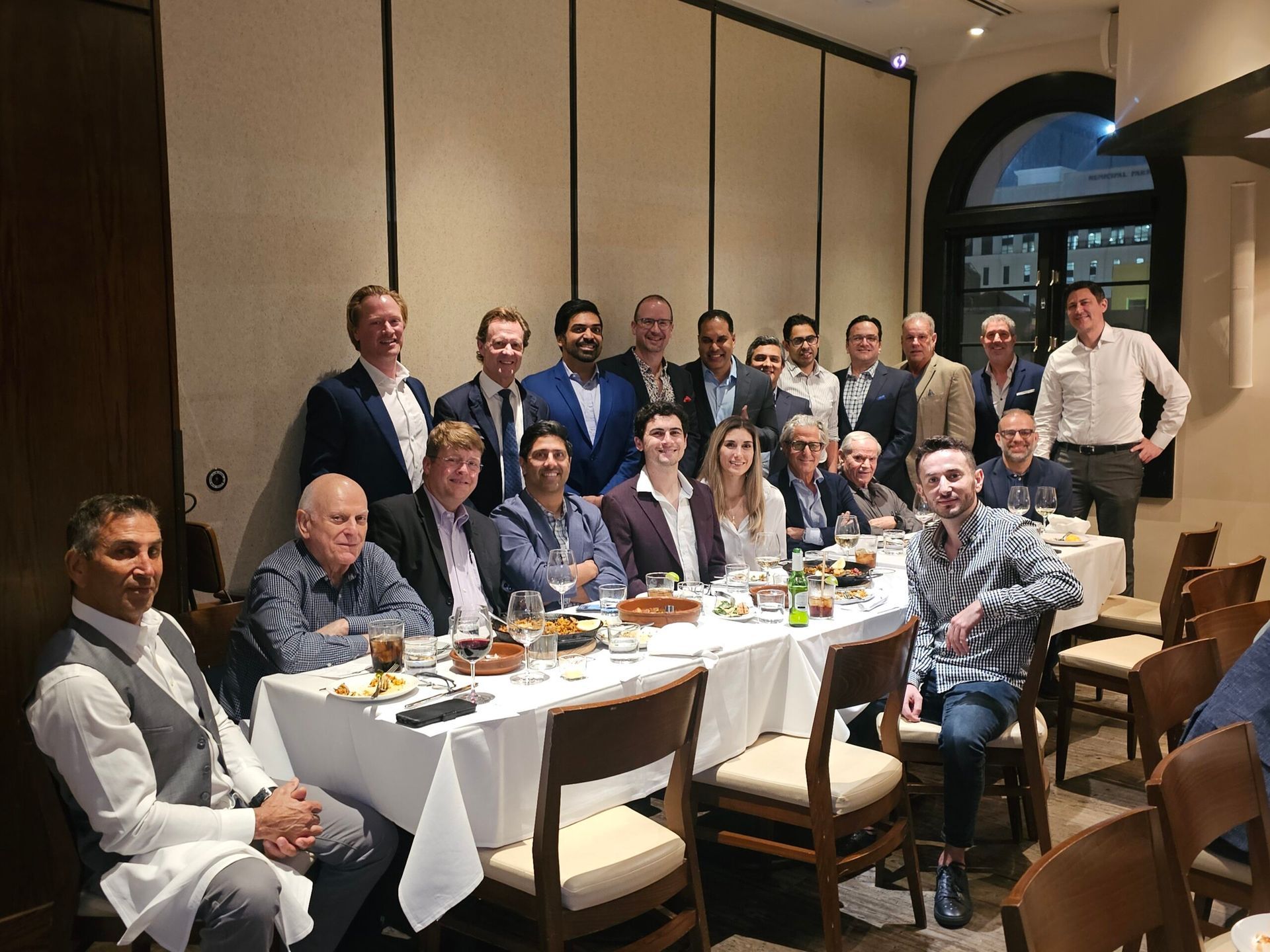 A group of people are sitting at a long table in a restaurant.