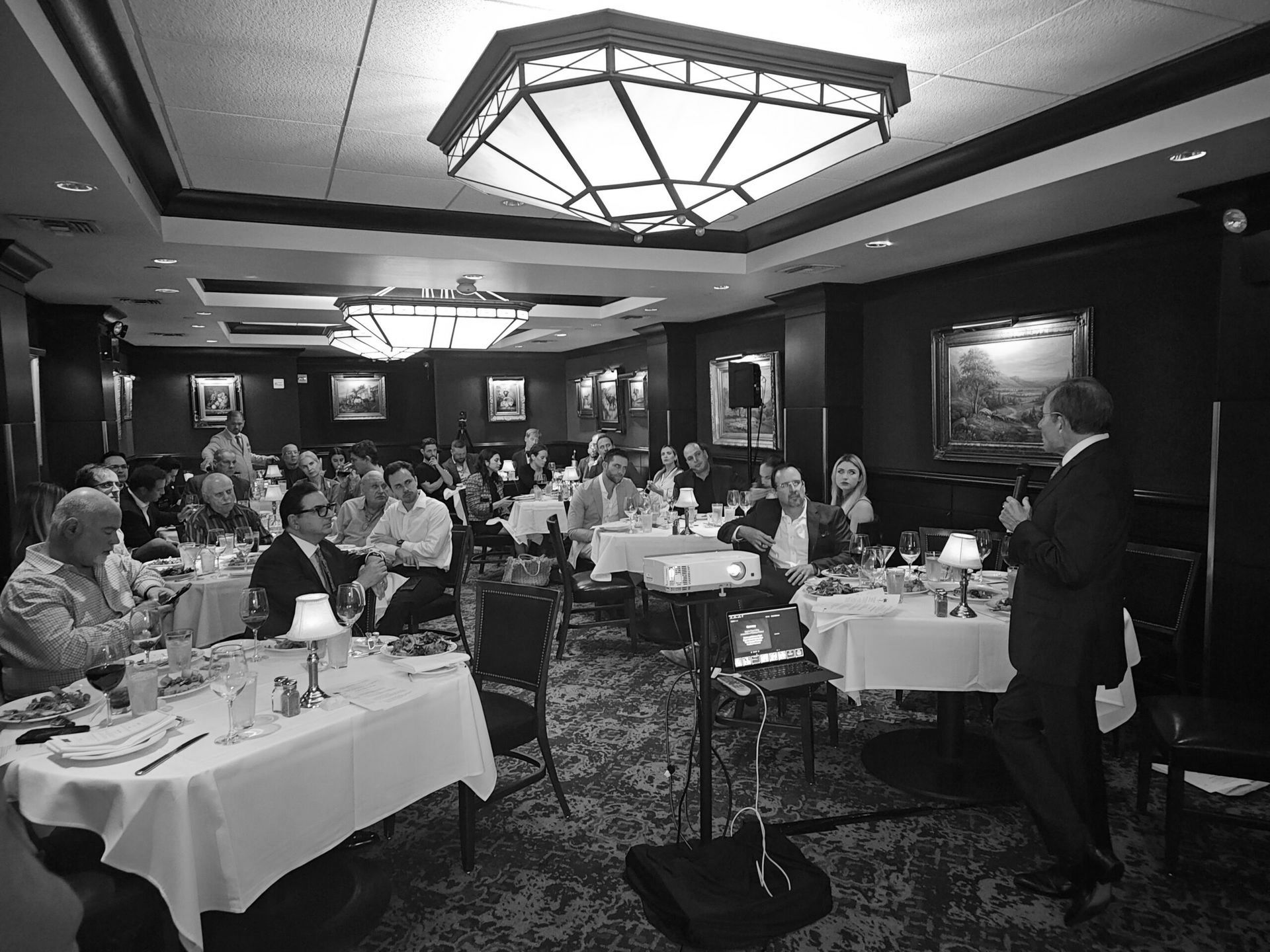 A Miami Society of Plastic Surgeons dinner meeting with a keynote speaker providing learning for the members at a restaurant.