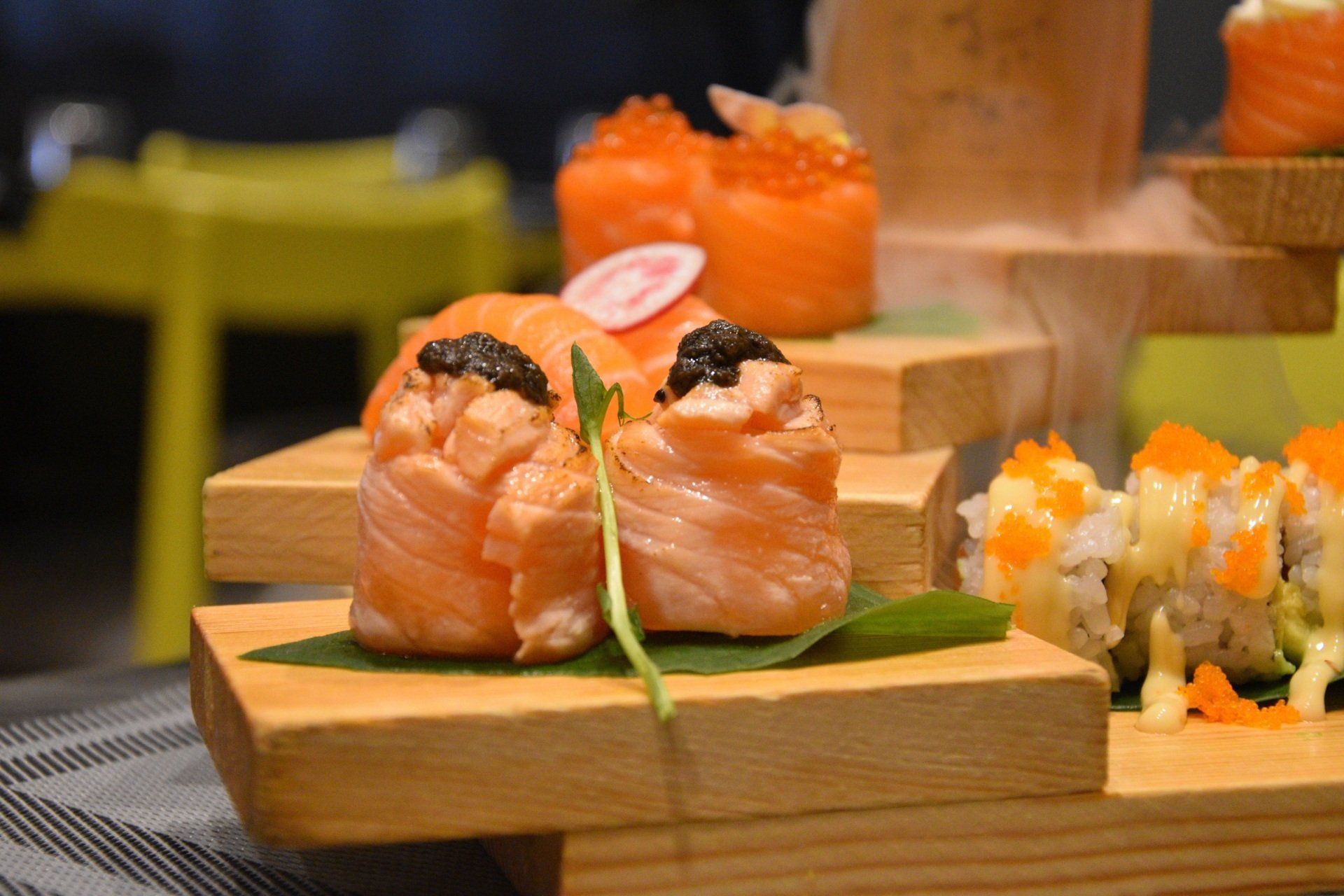 Sushi roll e nigiri di salmone su vassoi di legno in un ristorante