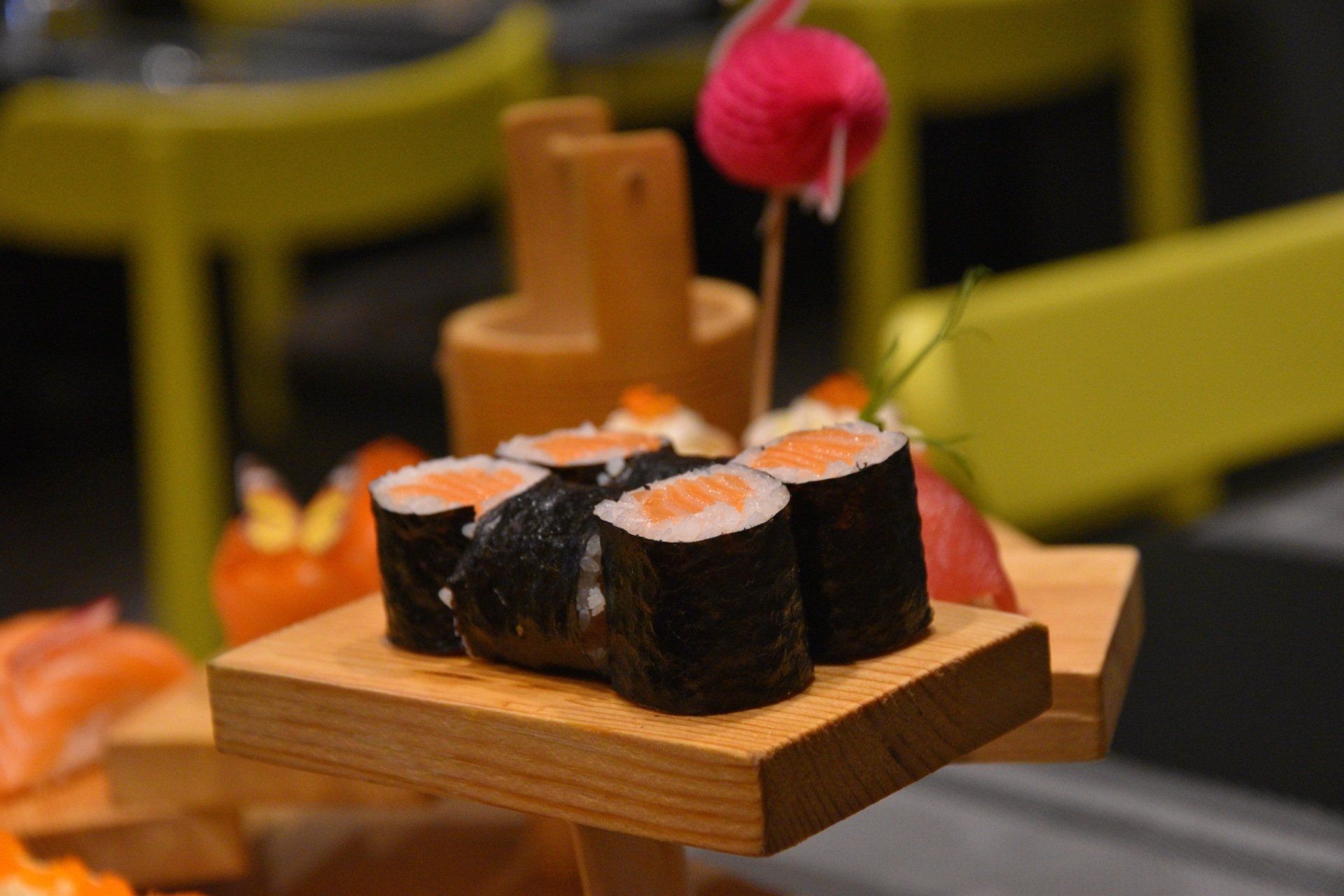 Sushi roll su un vassoio di legno con bacchette in un ristorante.