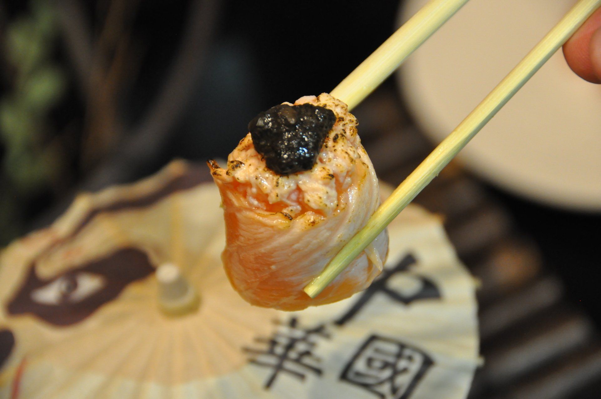 Spiedino di frutti di mare grigliati con panatura nera, cotto su una griglia da tavolo.