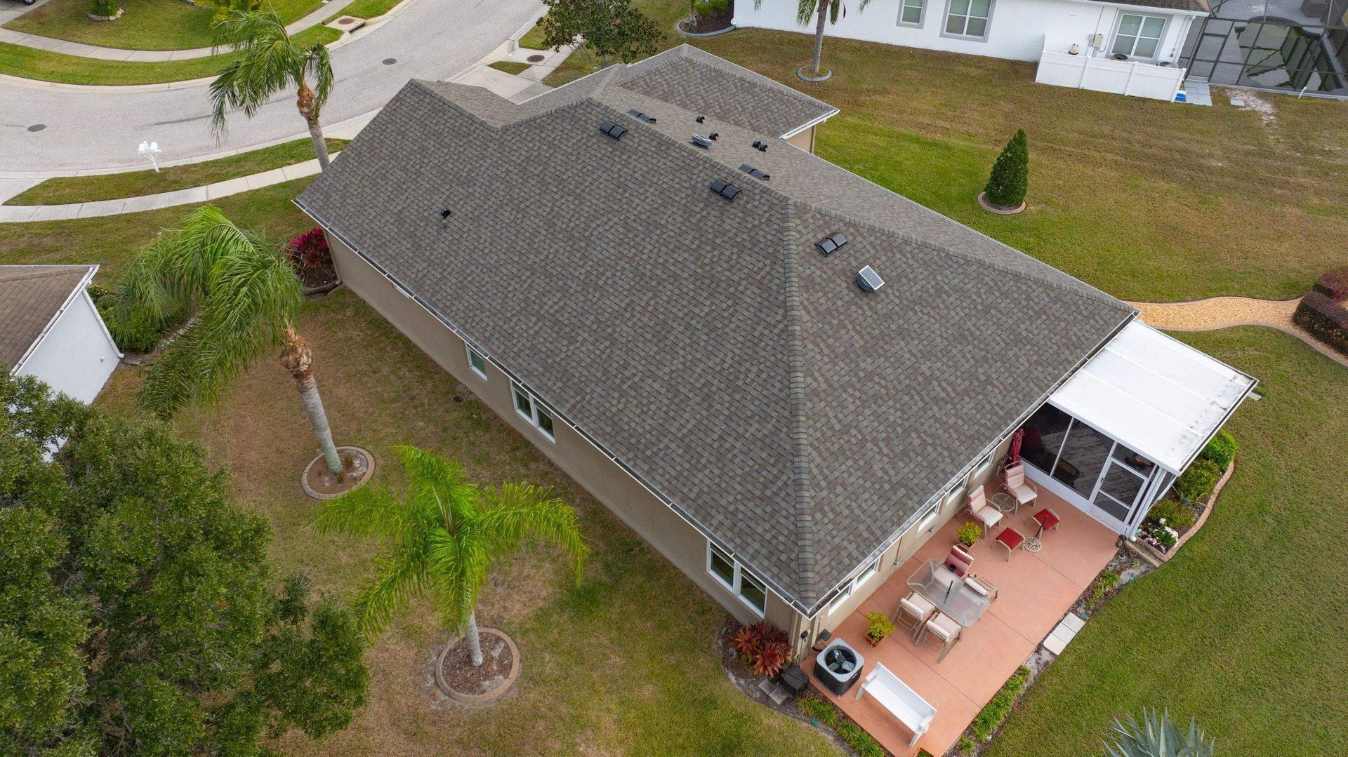 Overhead drone view of a newly installed CertainTeed Landmark Weathered Wood architectural shingle roof in Palm Cove, Wesley Chapel, Florida.