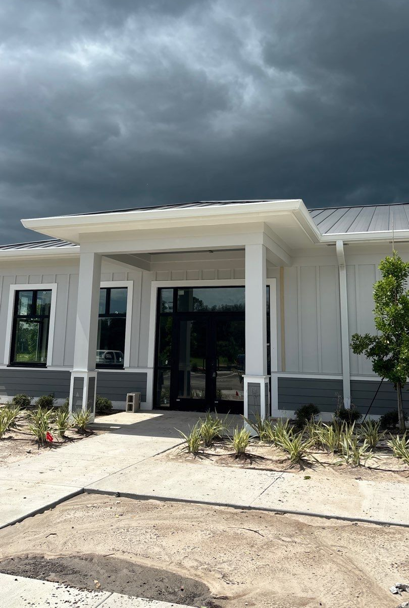 Harpro Forest Lakes Clubhouse featuring a newly installed Charcoal Gray standing seam metal roof and white seamless gutters in Zephyrhills, FL.