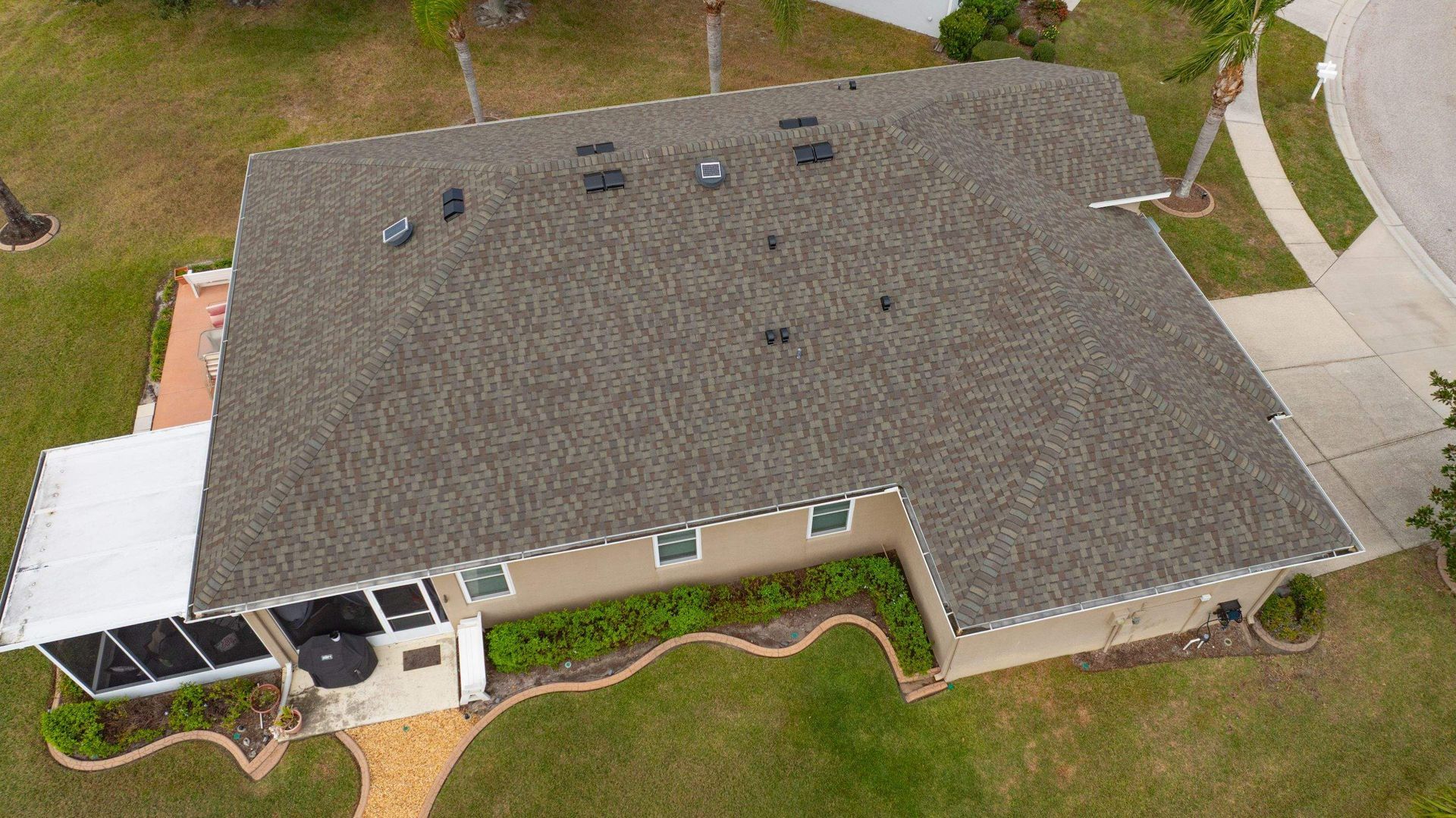 Aerial view of a large Florida shingle roof with multiple hips, valleys, and roof penetrations that
