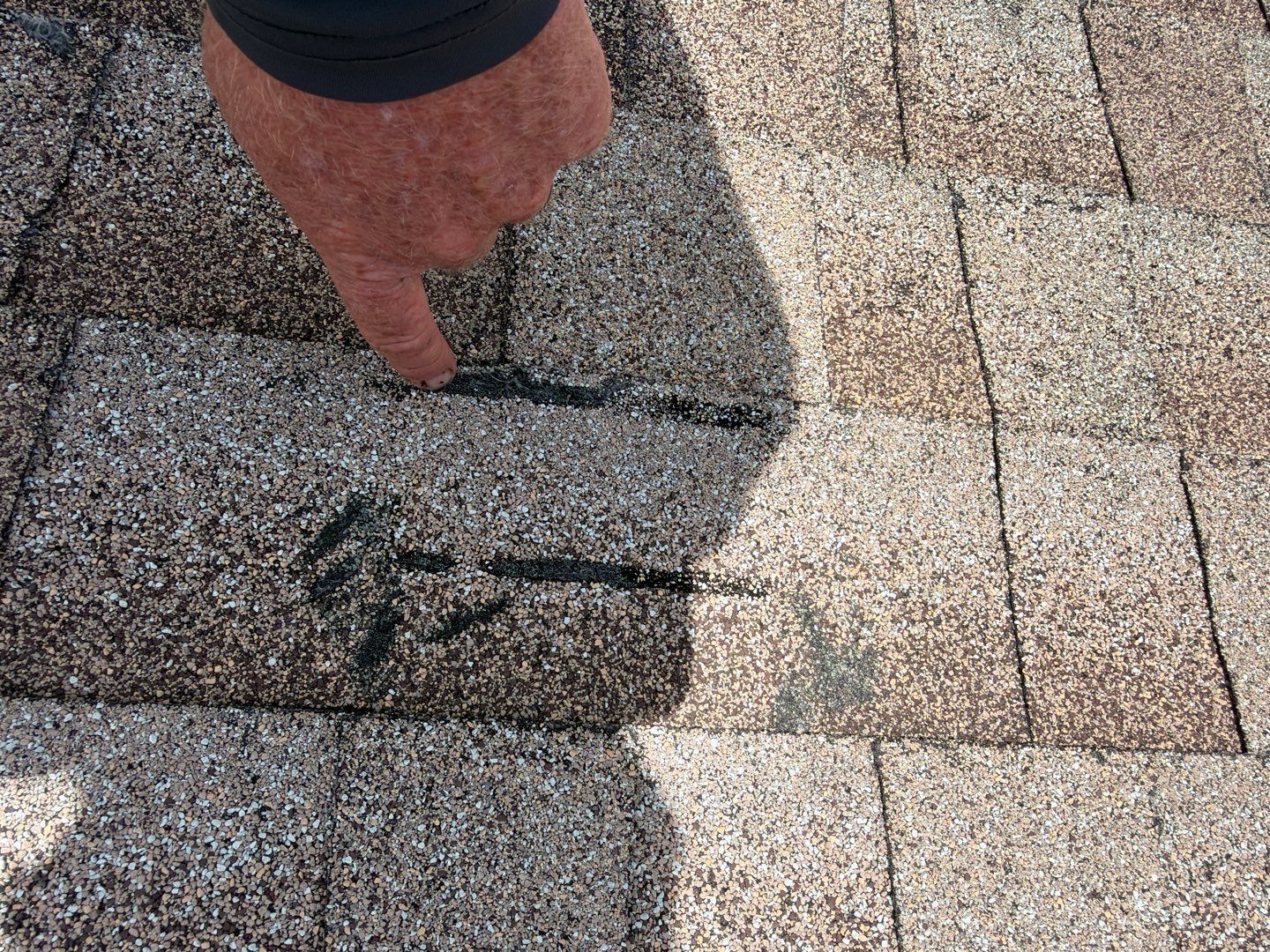Close-up roof inspection showing separation and deterioration on an older shingle roofing system in Zephyrhills, Florida.