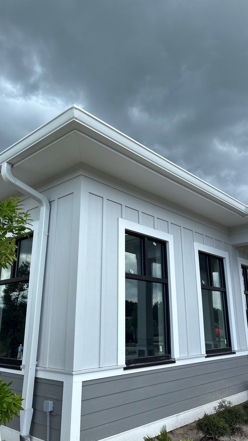 Detail view of the TCM LOK Charcoal Gray standing seam metal roof with white gutters on the Harpro Forest Lakes Clubhouse in Zephyrhills, Florida.