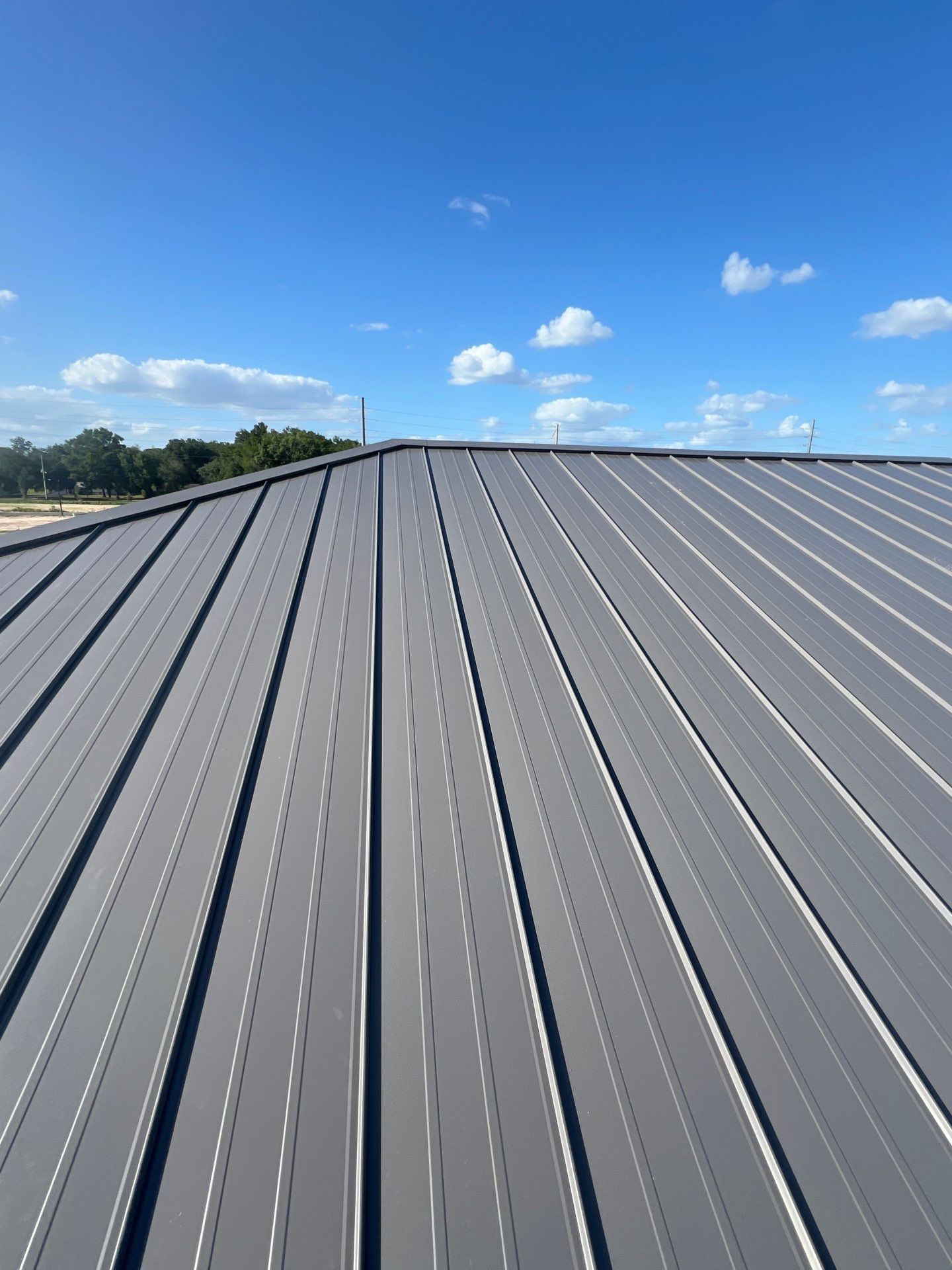 Newly installed TCM LOK 24-gauge standing seam metal roof in Charcoal Gray on the Harpro Forest Lakes Clubhouse in Zephyrhills, Florida.