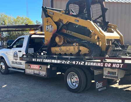 White tow truck with a white box on the flatbed, parked on a sunny day.
